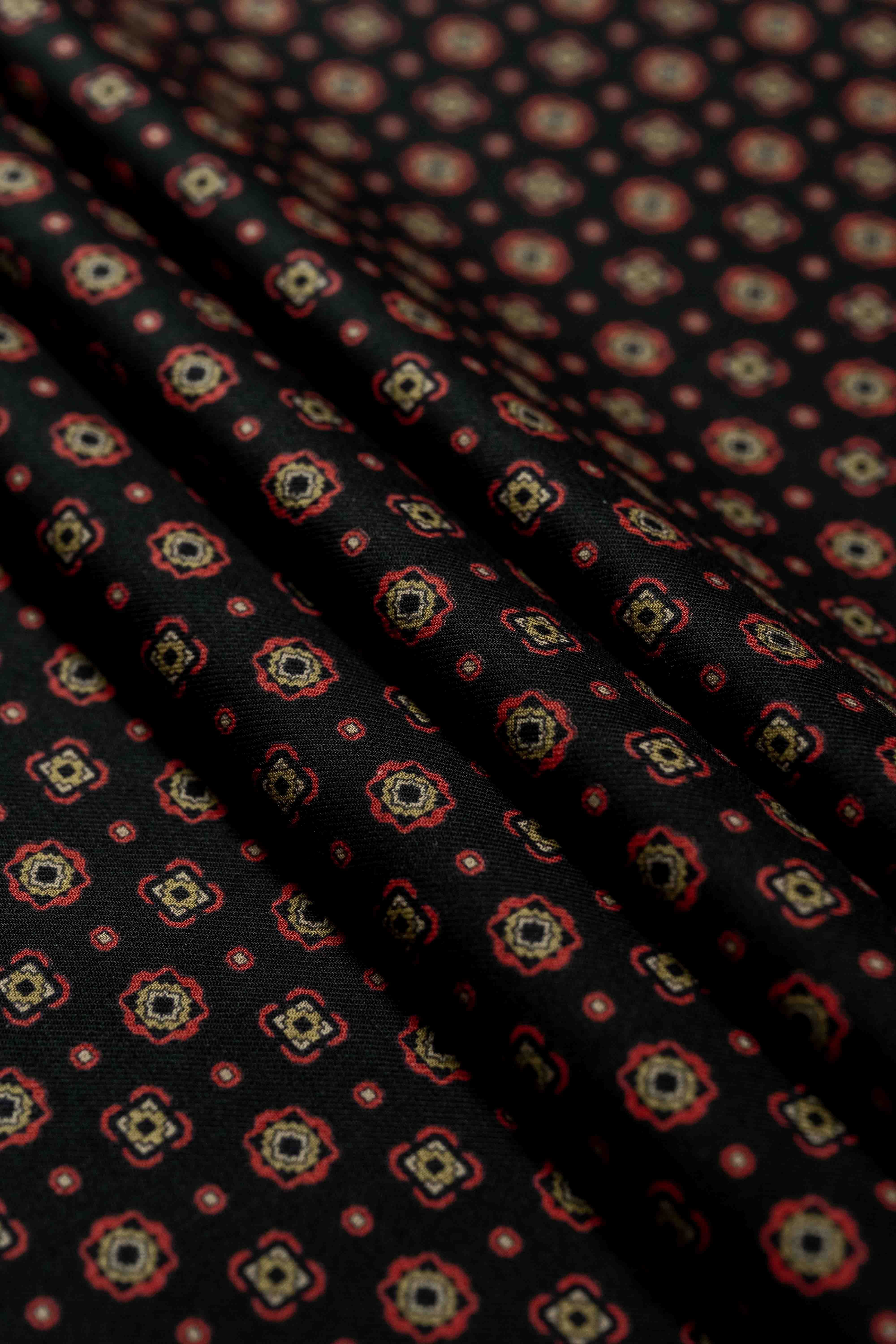 Vintage fabrics in black with intricate red and gold patterns, ideal for shirts and ties.