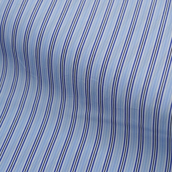Canclini striped fabric in light blue and navy, showcasing the playful design elements of Italian shirting.