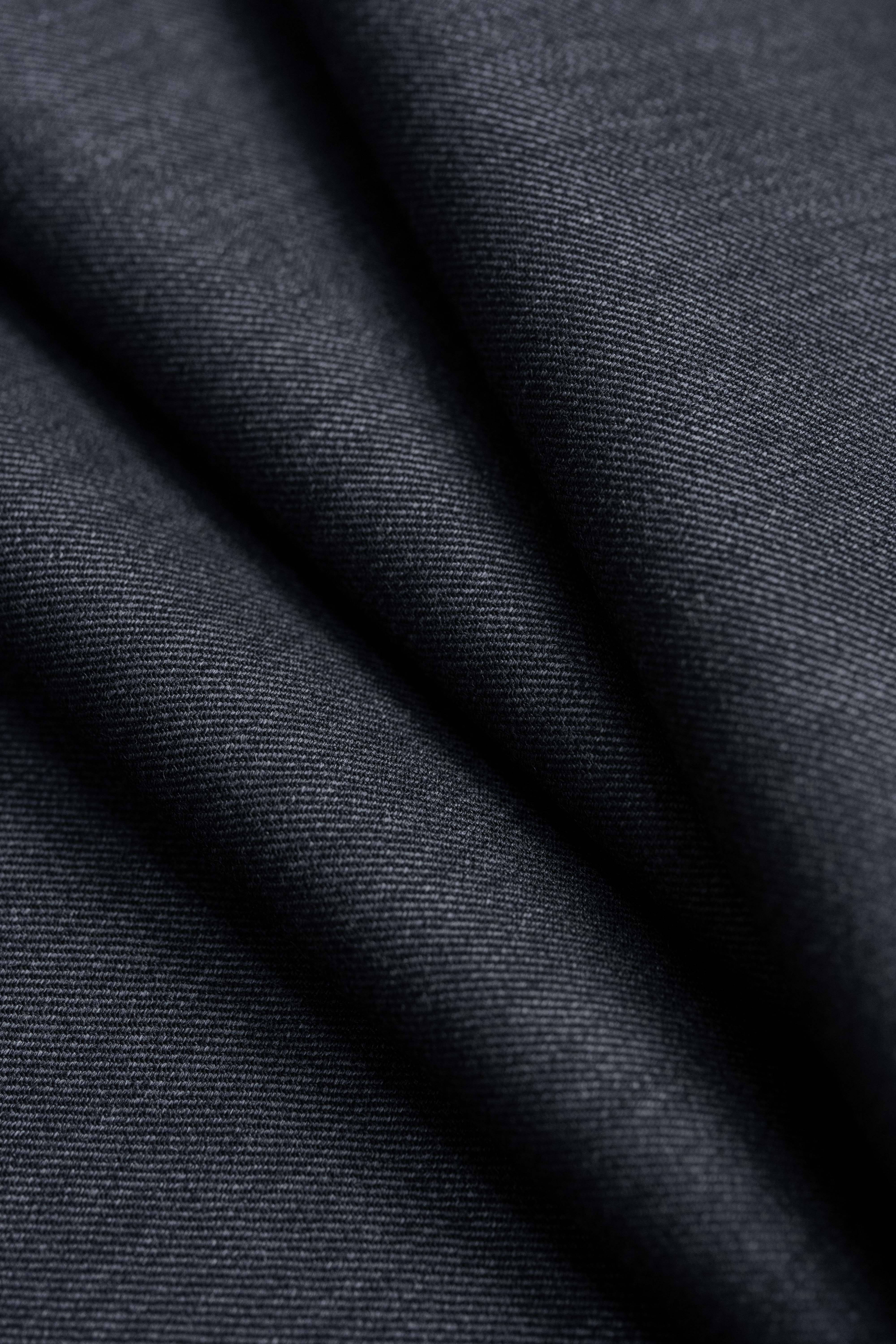 Dark grey Super 100s wool suiting fabric showcasing diagonal weave and soft sheen.