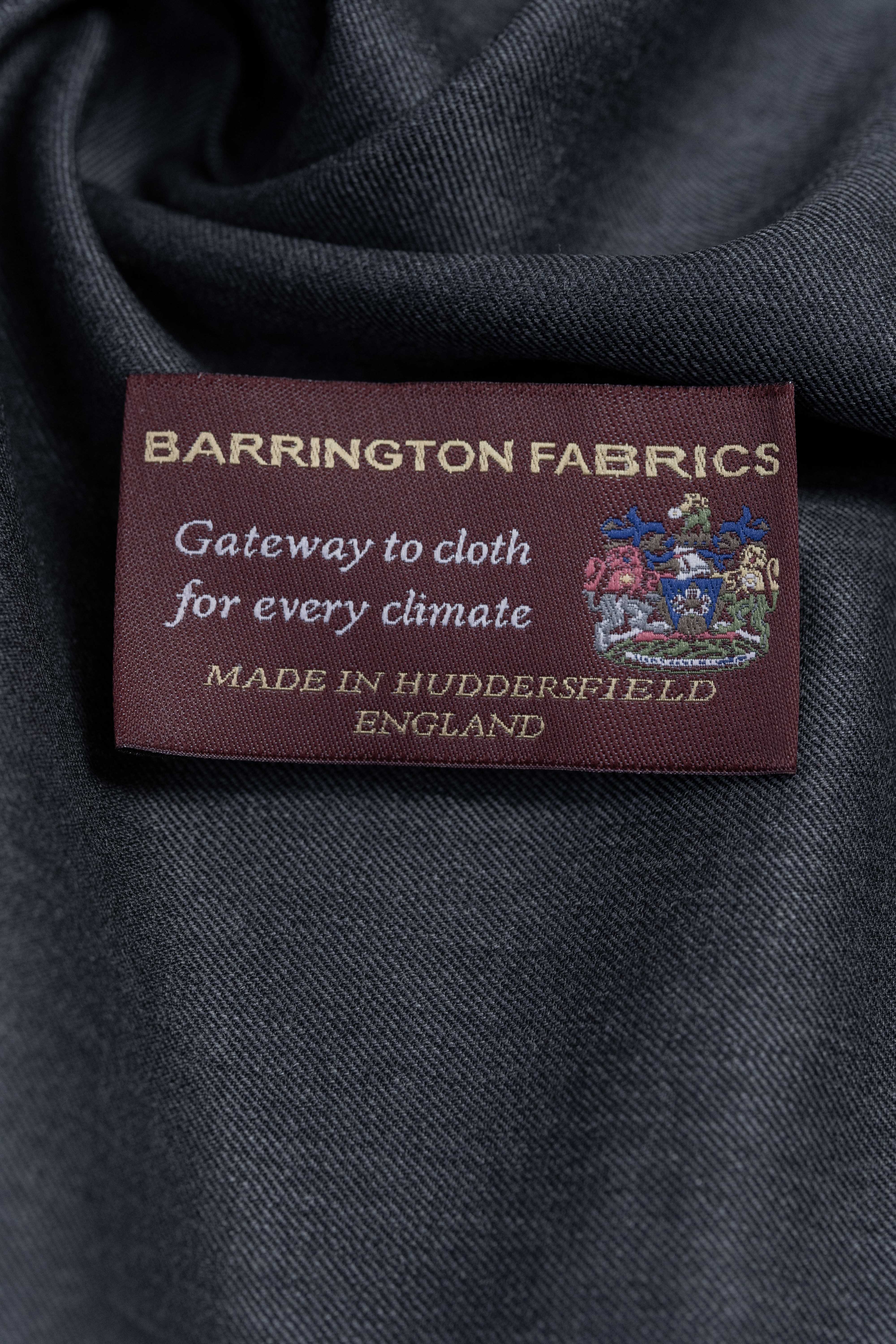 Barrington Fabrics label on dark grey Super 100s wool suiting fabric, showcasing quality craftsmanship.