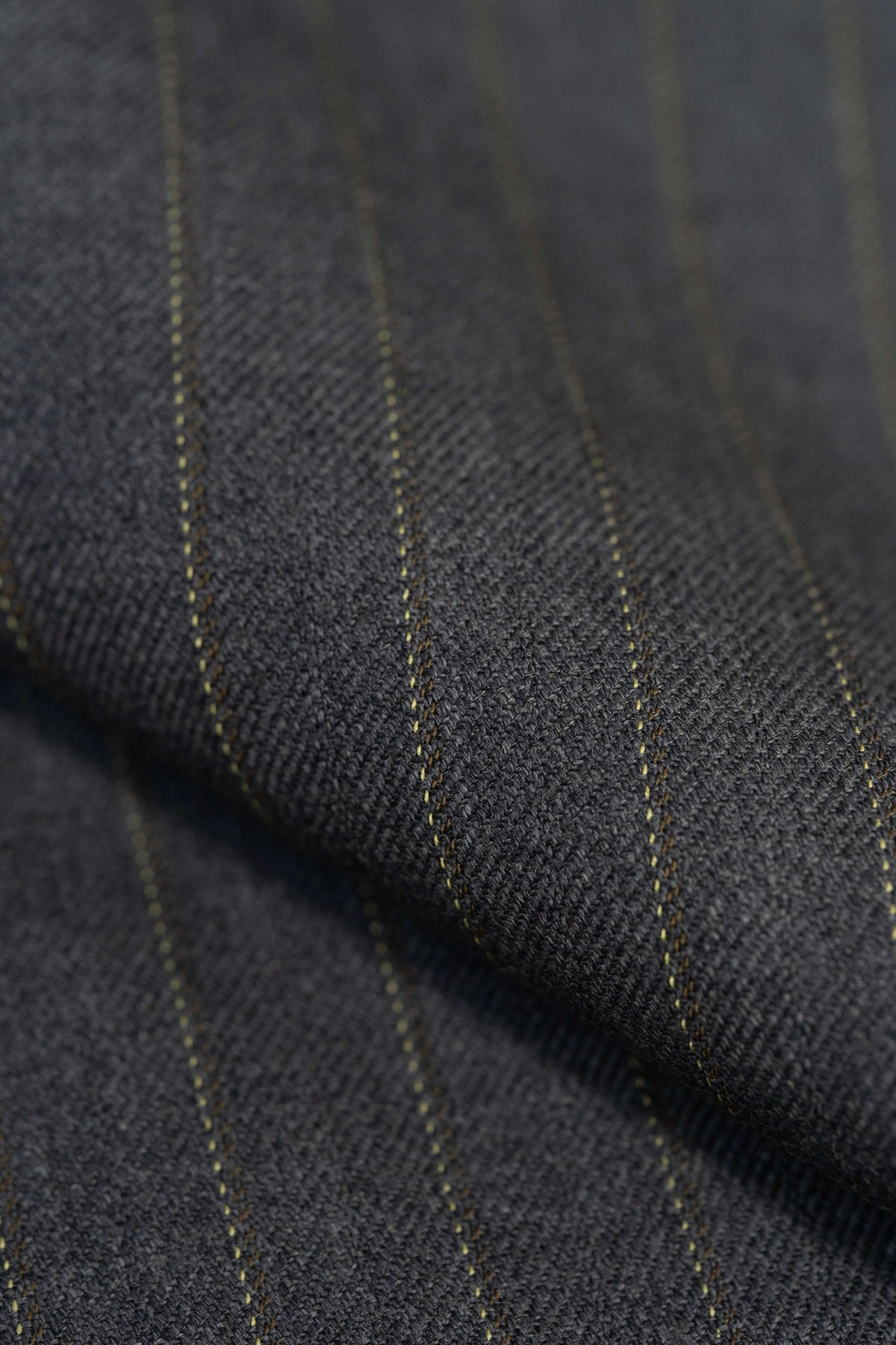 Close-up of Barrington Grey super merino wool suiting fabric with yellow stripes, showcasing luxurious texture and quality.