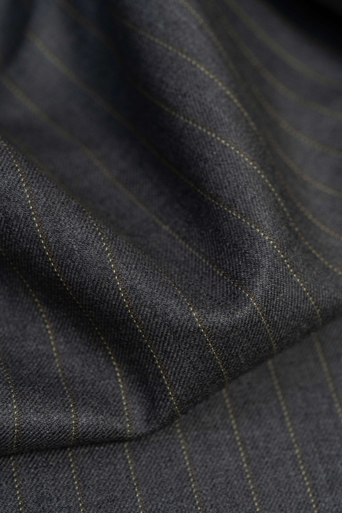 Close-up of Barrington Grey super merino wool suiting fabric with yellow stripe, showcasing the texture and pattern.