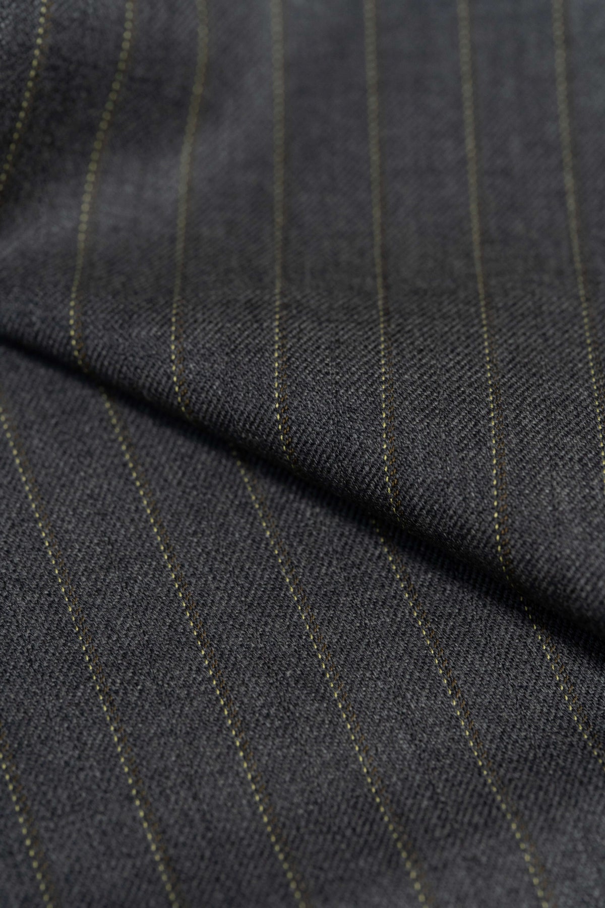 Close-up of Barrington Grey super merino wool suiting fabric with yellow stripe, showcasing its fine texture and stripes.
