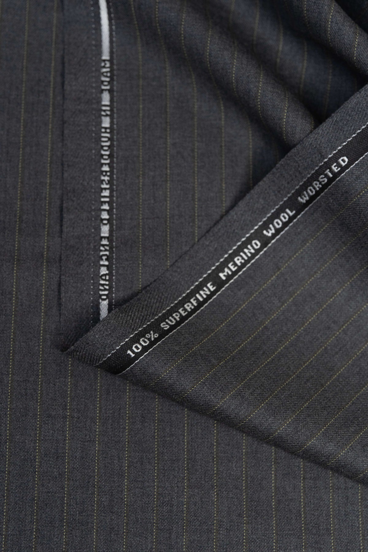 Close-up of Barrington Grey super merino wool suiting fabric with yellow stripe, showcasing fine quality and texture.
