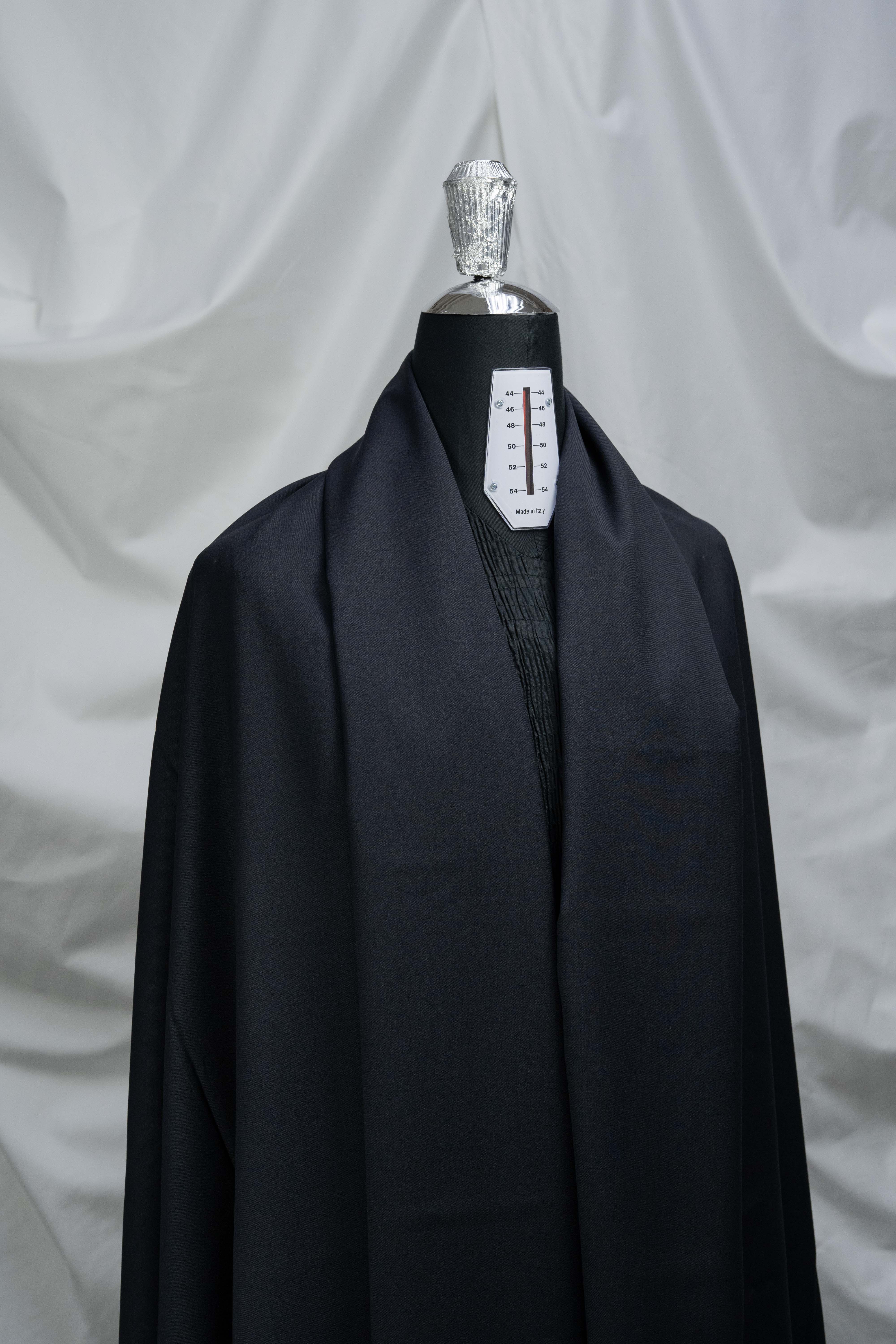 England Black Super 100's Wool Suiting Fabric displayed on a mannequin, showcasing its elegant texture and quality.