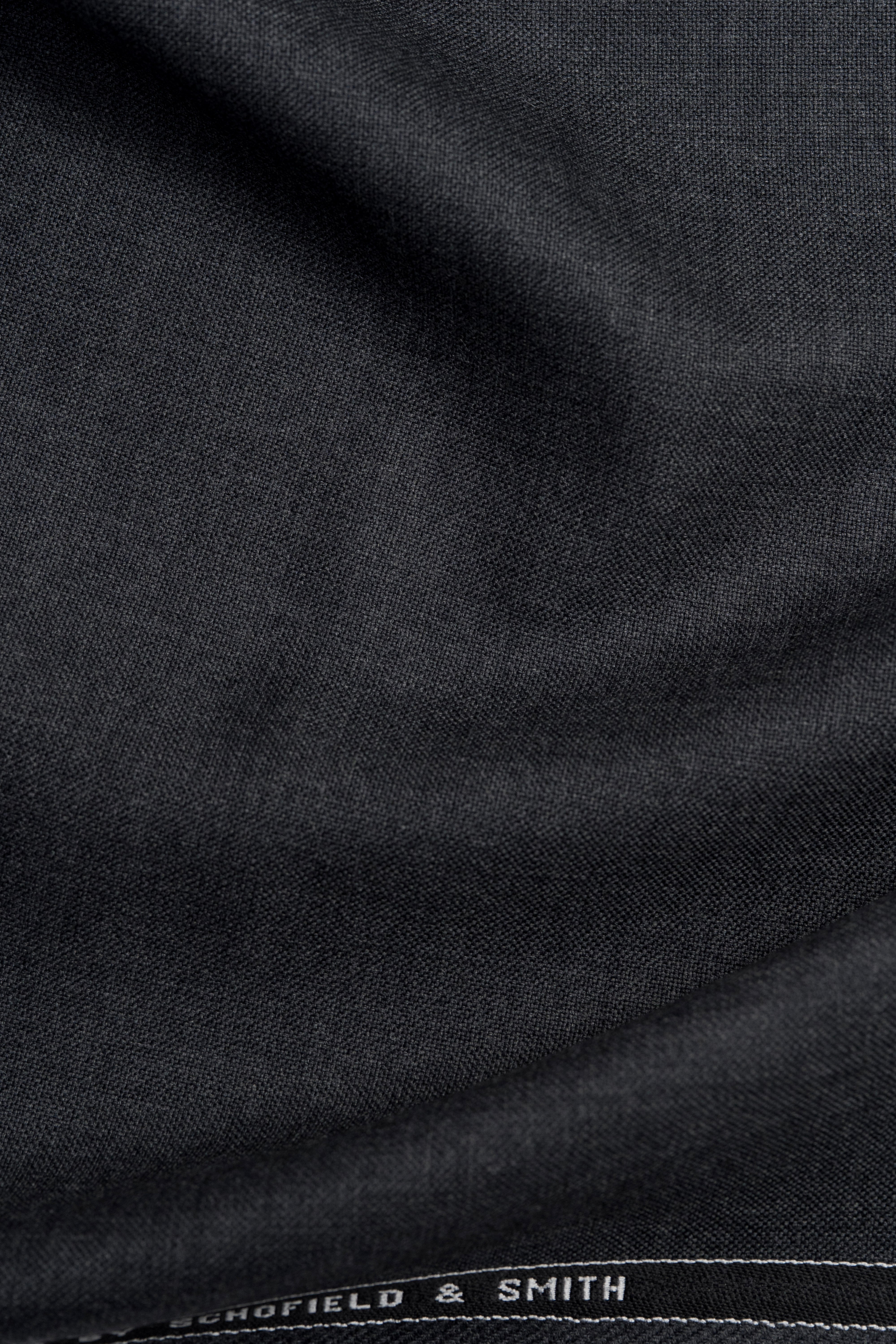 Groves & Lindley dark grey wool suit fabric showcasing its smooth texture and rich color.