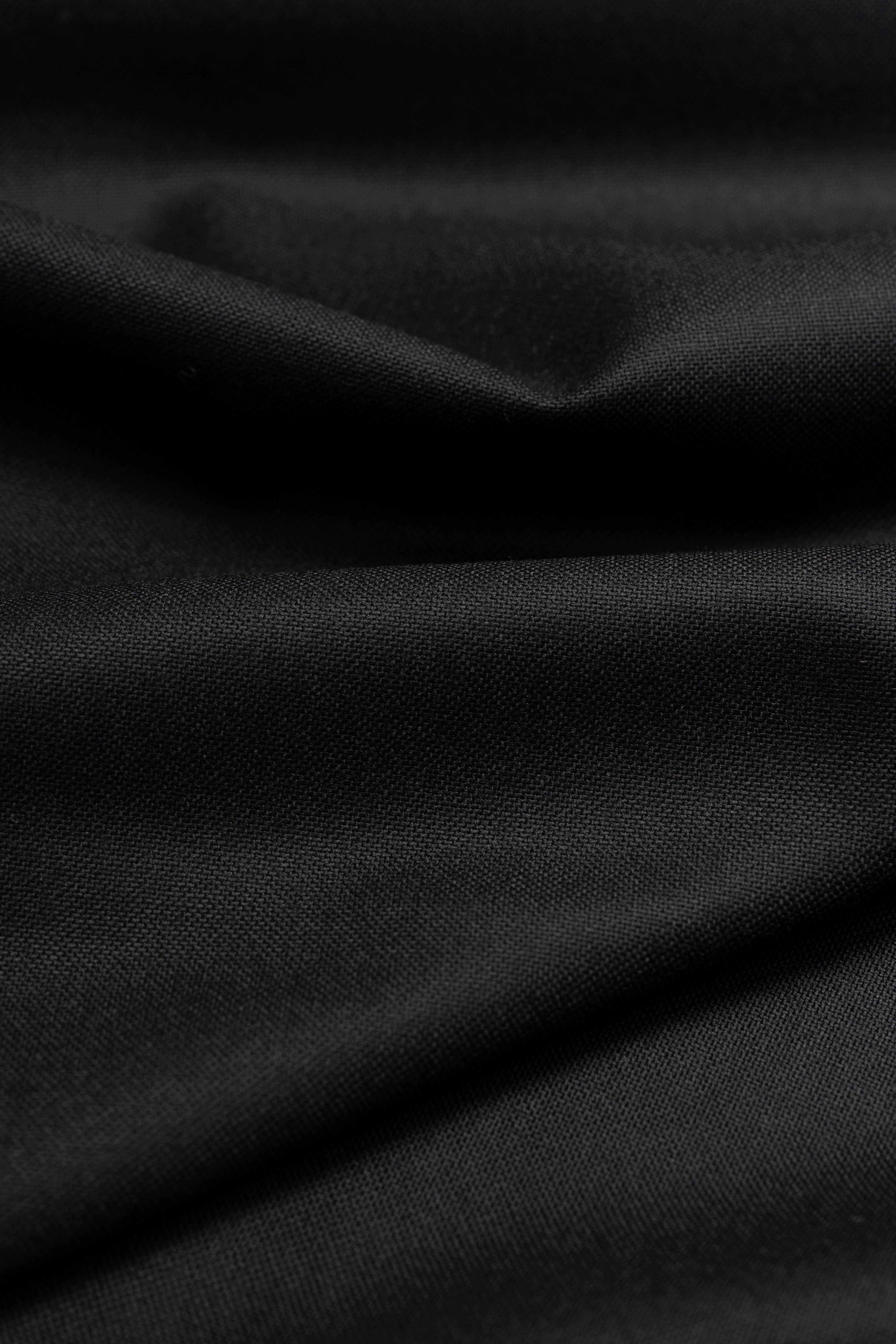 black wool suit fabric in a smooth, draped texture, showcasing the richness of the material.