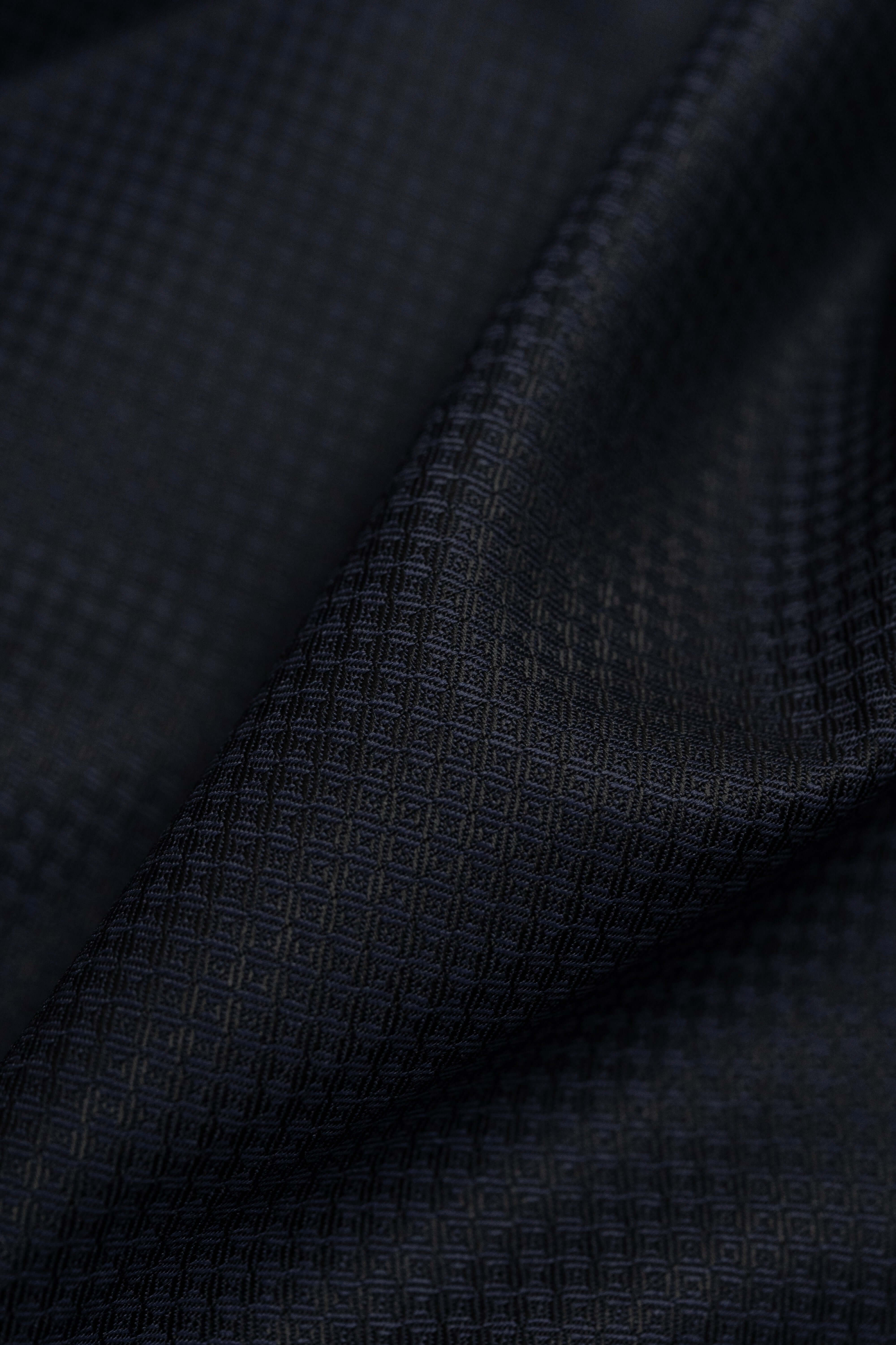 Close-up of Barrington Panama Weave fabric featuring a dark navy geometric pattern in wool suiting.