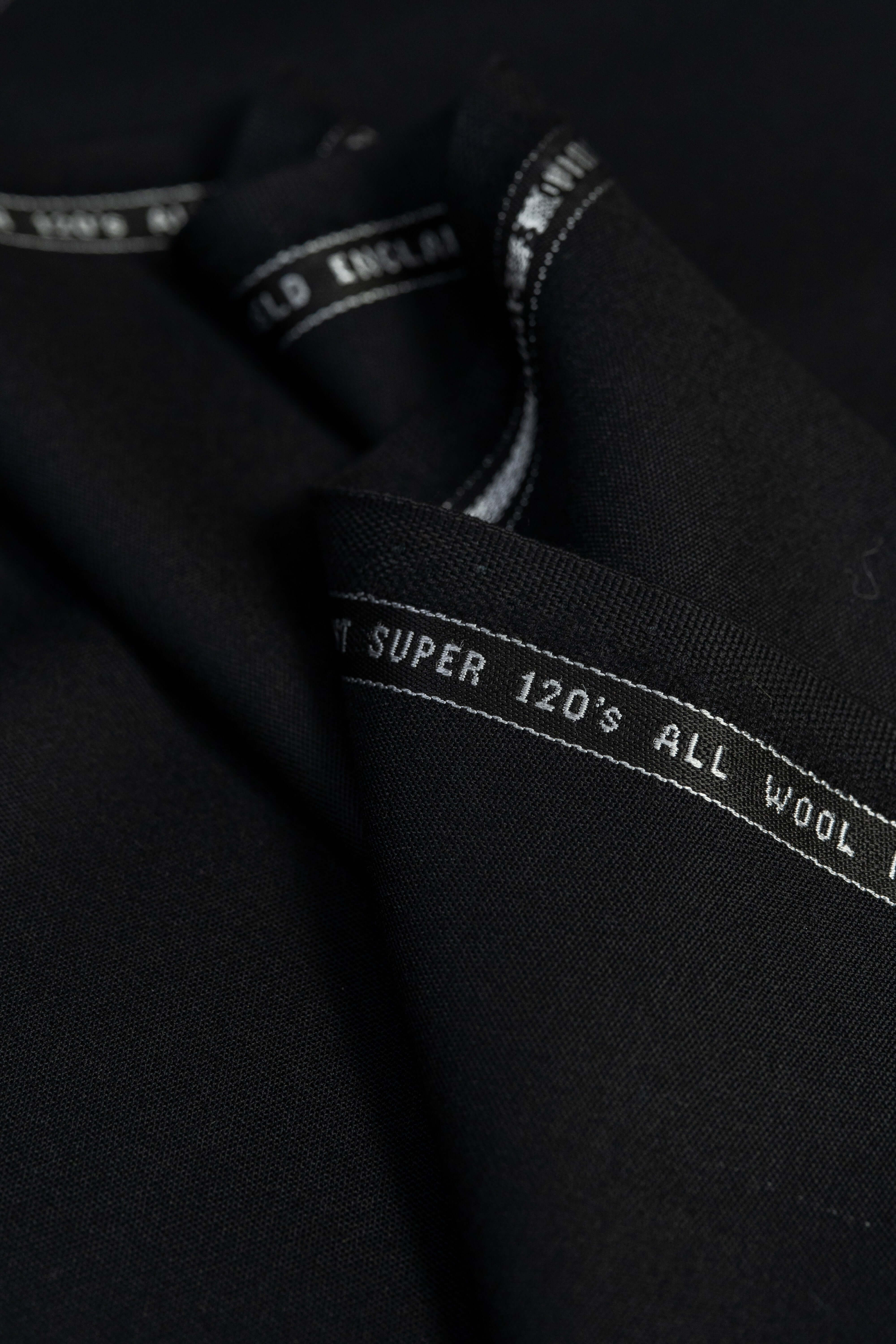 Groves & Lindley Super 120's worsted plain black wool suit fabric close-up, showcasing its rich texture.