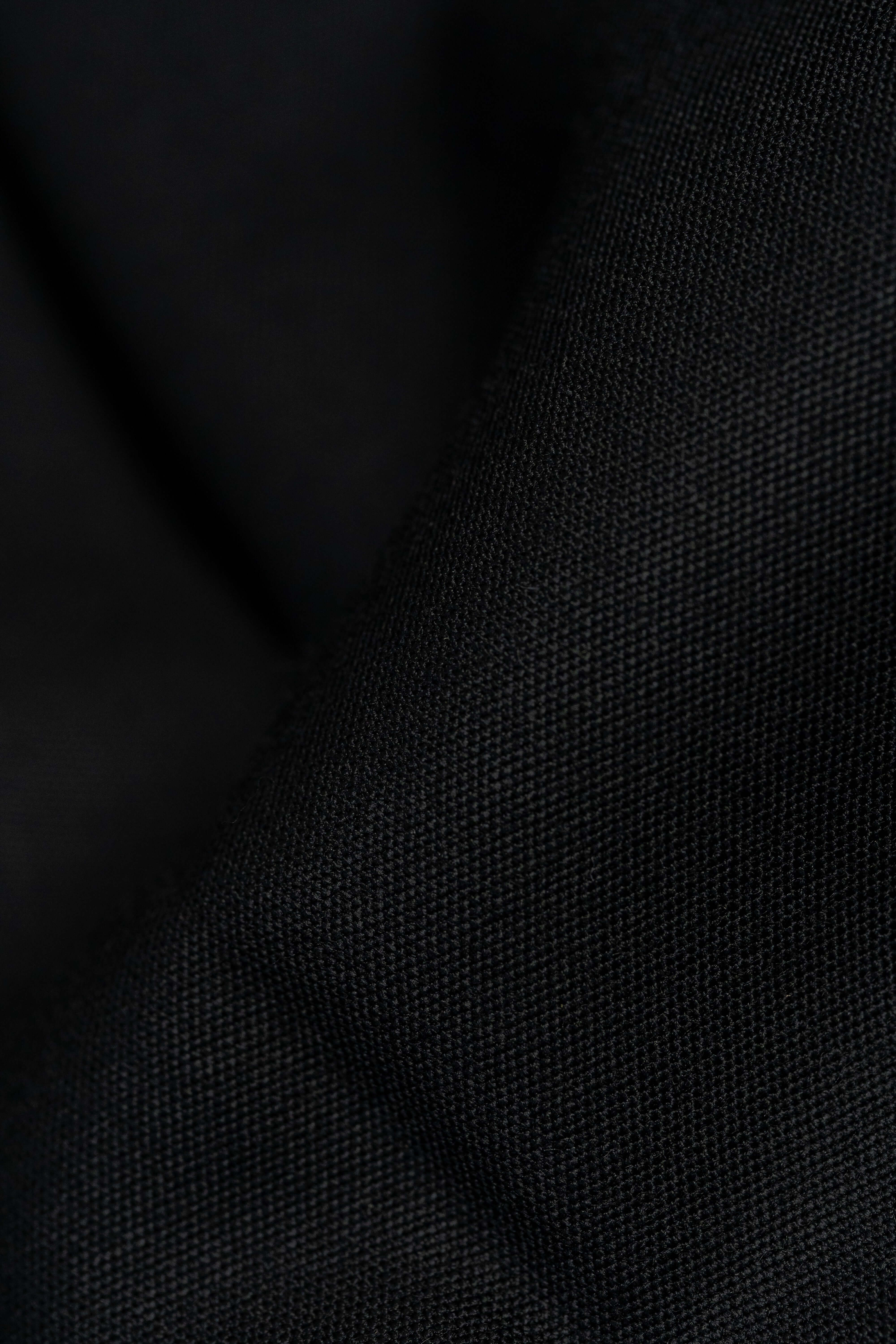 Close-up of Groves & Lindley black wool suit fabric showcasing its fine texture.