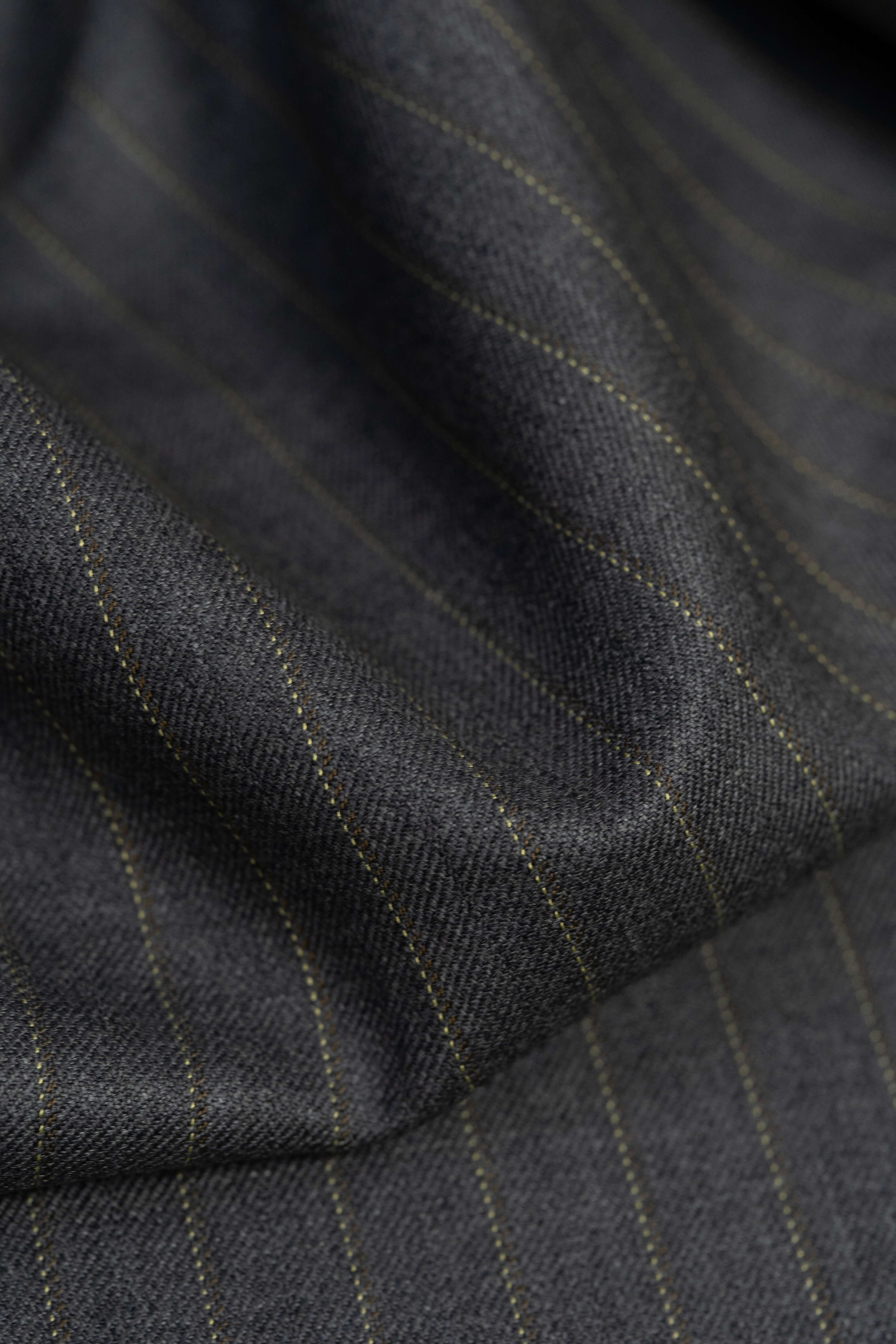 Close-up of Barrington Grey super merino wool suiting fabric with yellow stripe, showcasing the texture and pattern.