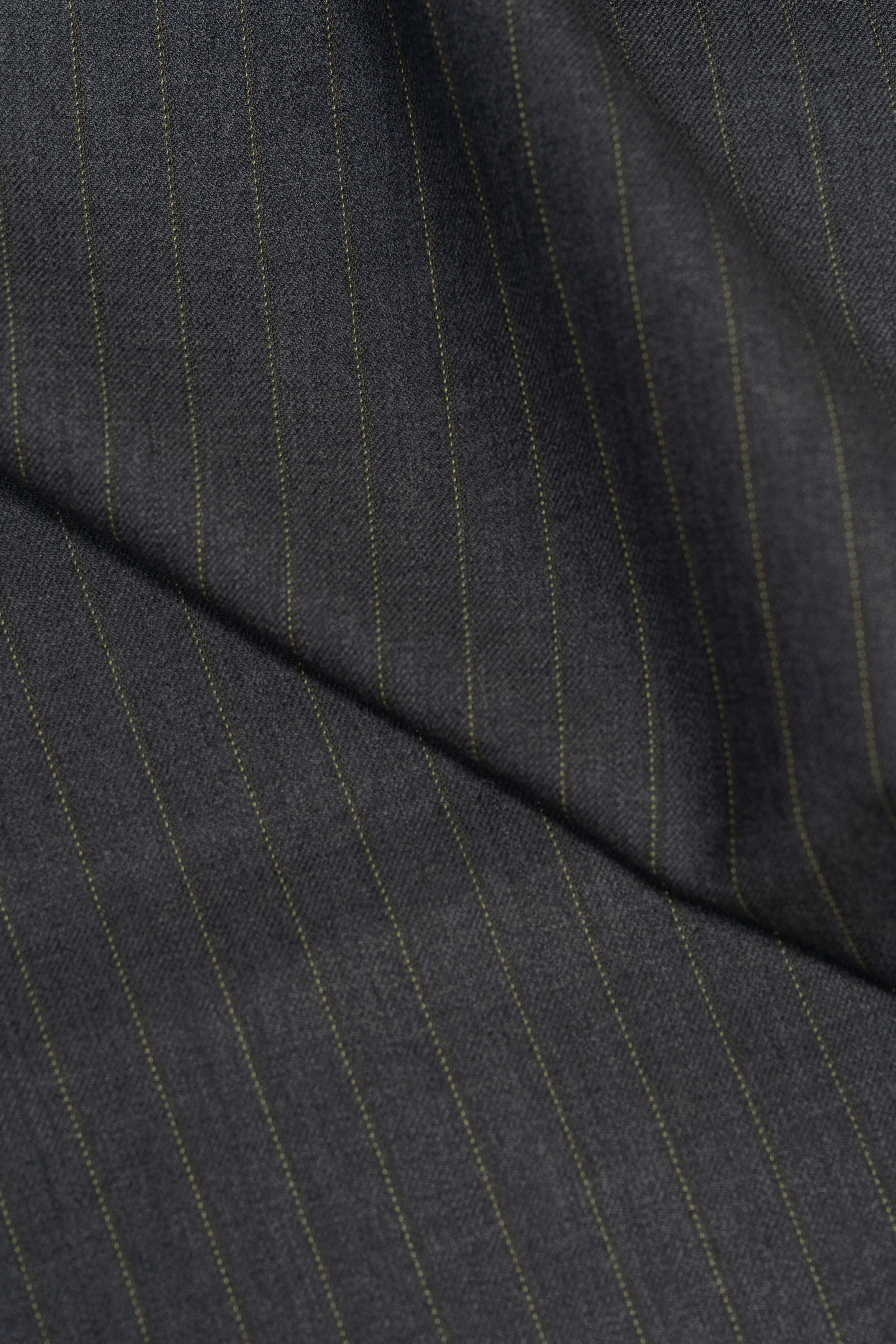 Close-up of Barrington Grey super merino wool suiting fabric with yellow stripe, showcasing its texture and design.