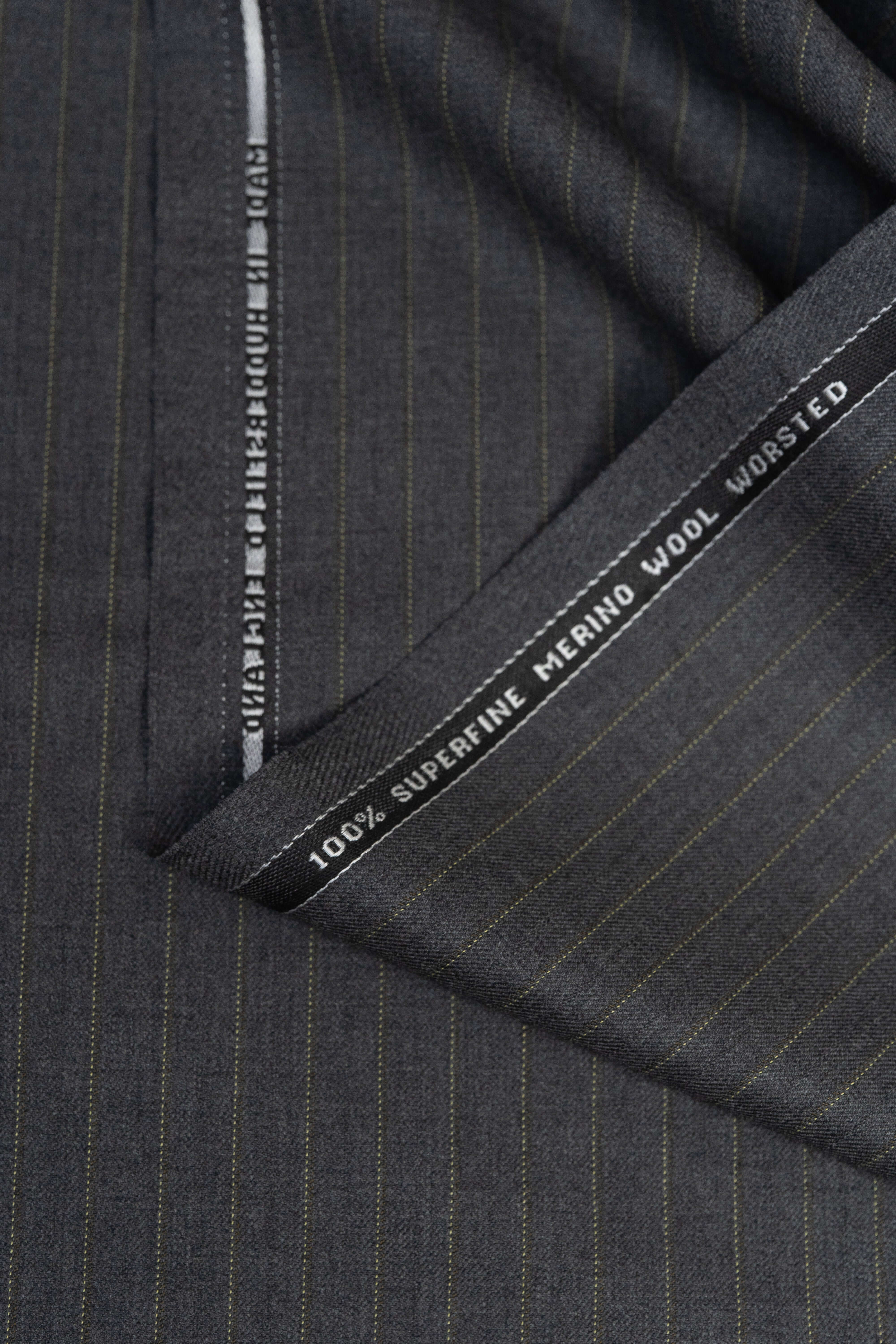 Close-up of Barrington Grey super merino wool suiting fabric with yellow stripe, showcasing fine quality and texture.
