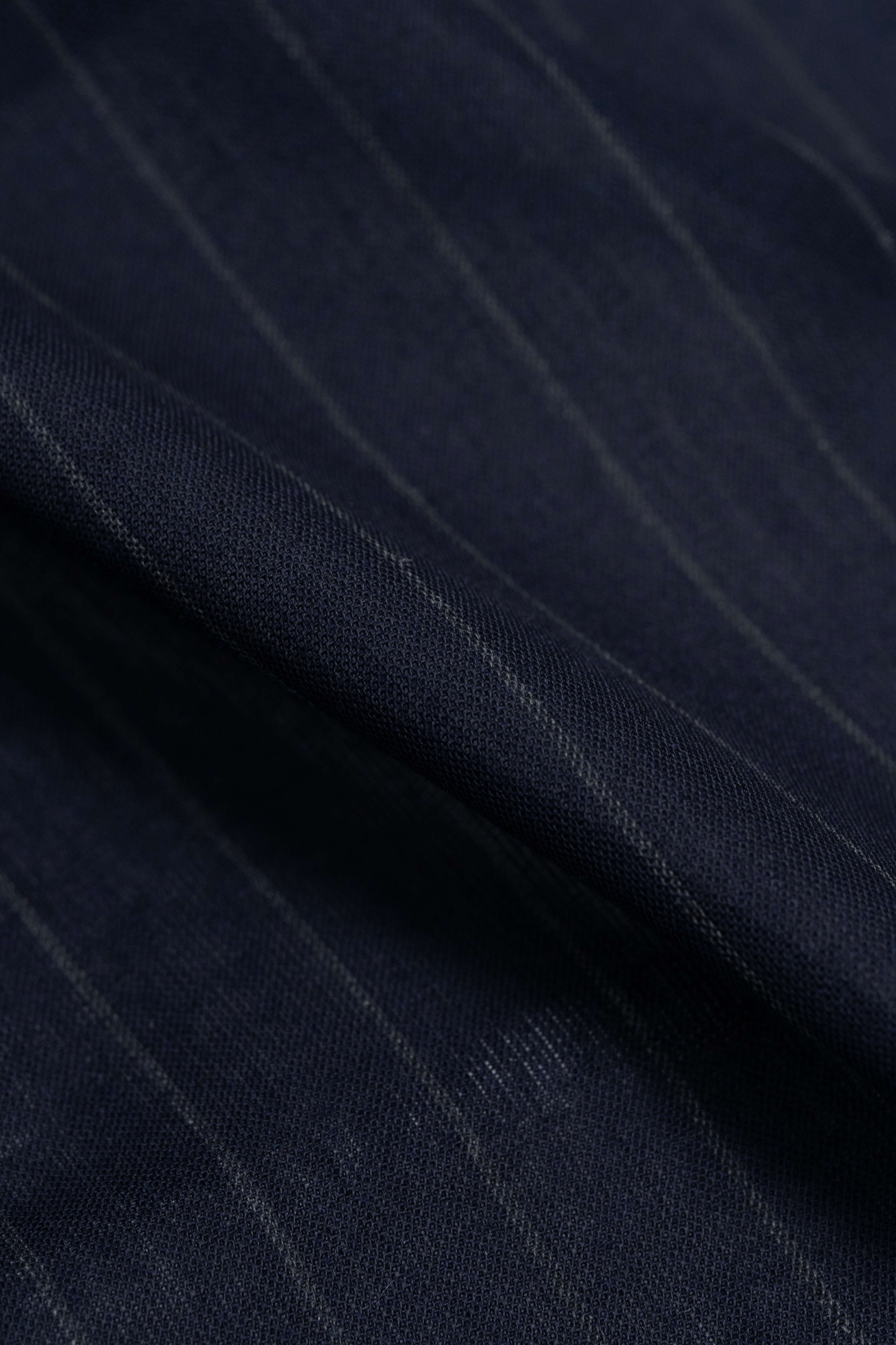 Close-up of dark blue stripe wool mohair suiting fabric showcasing fine texture and elegant stripes.