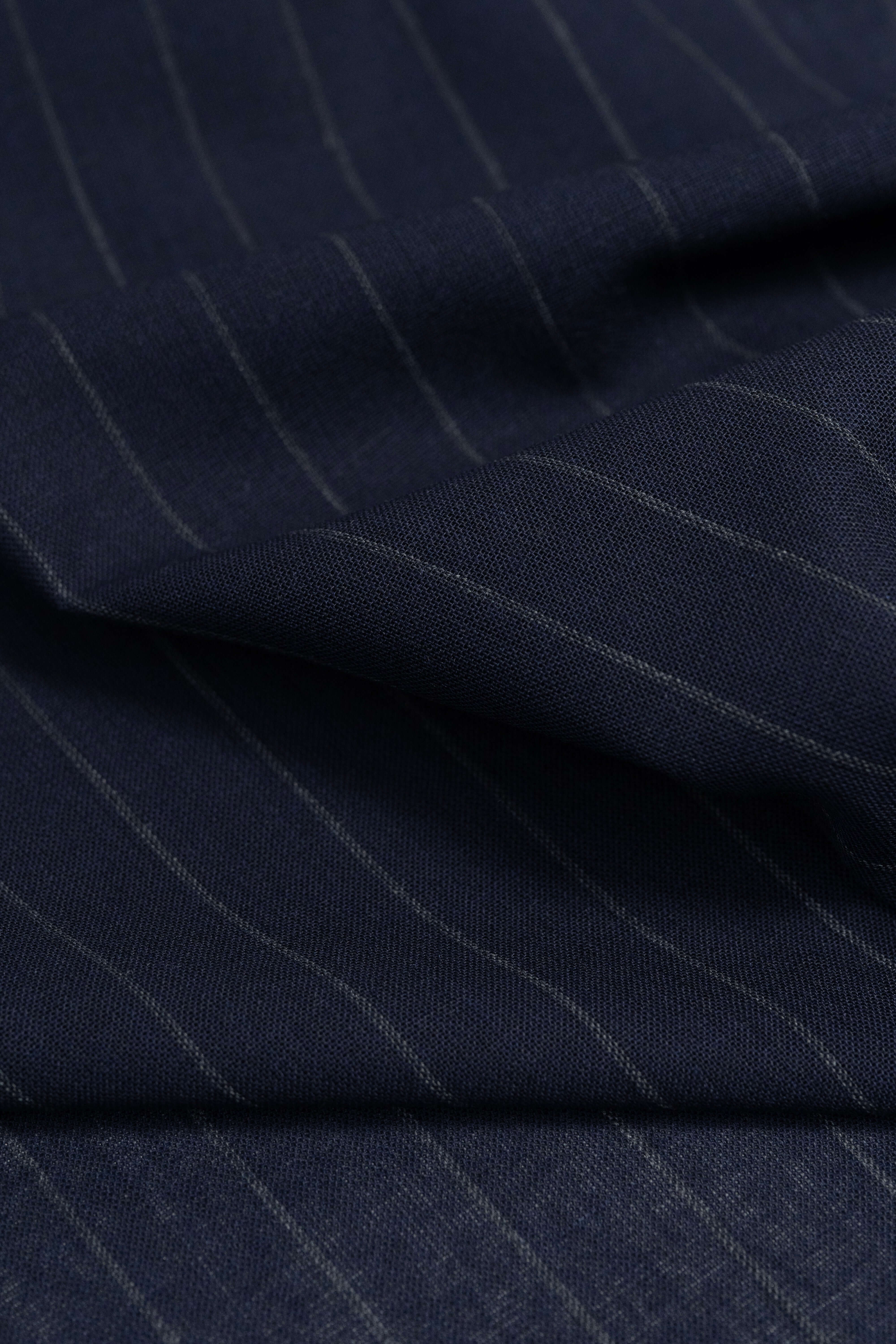Close-up of dark blue stripe wool mohair suiting fabric, showcasing fine stripes and rich texture.