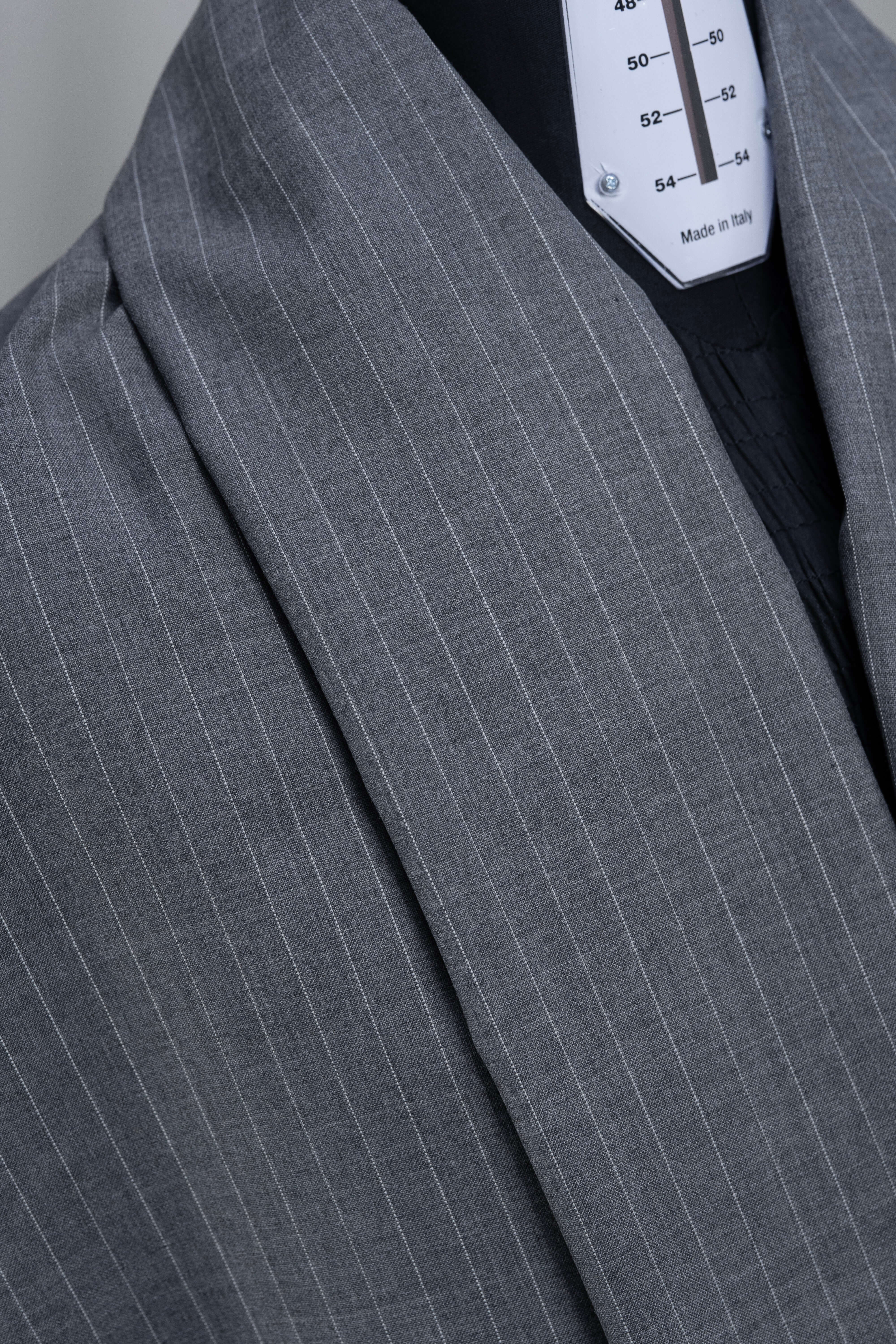 Close-up of grey stripe wool suiting fabric, showcasing the subtle pattern and texture for stylish trousers.