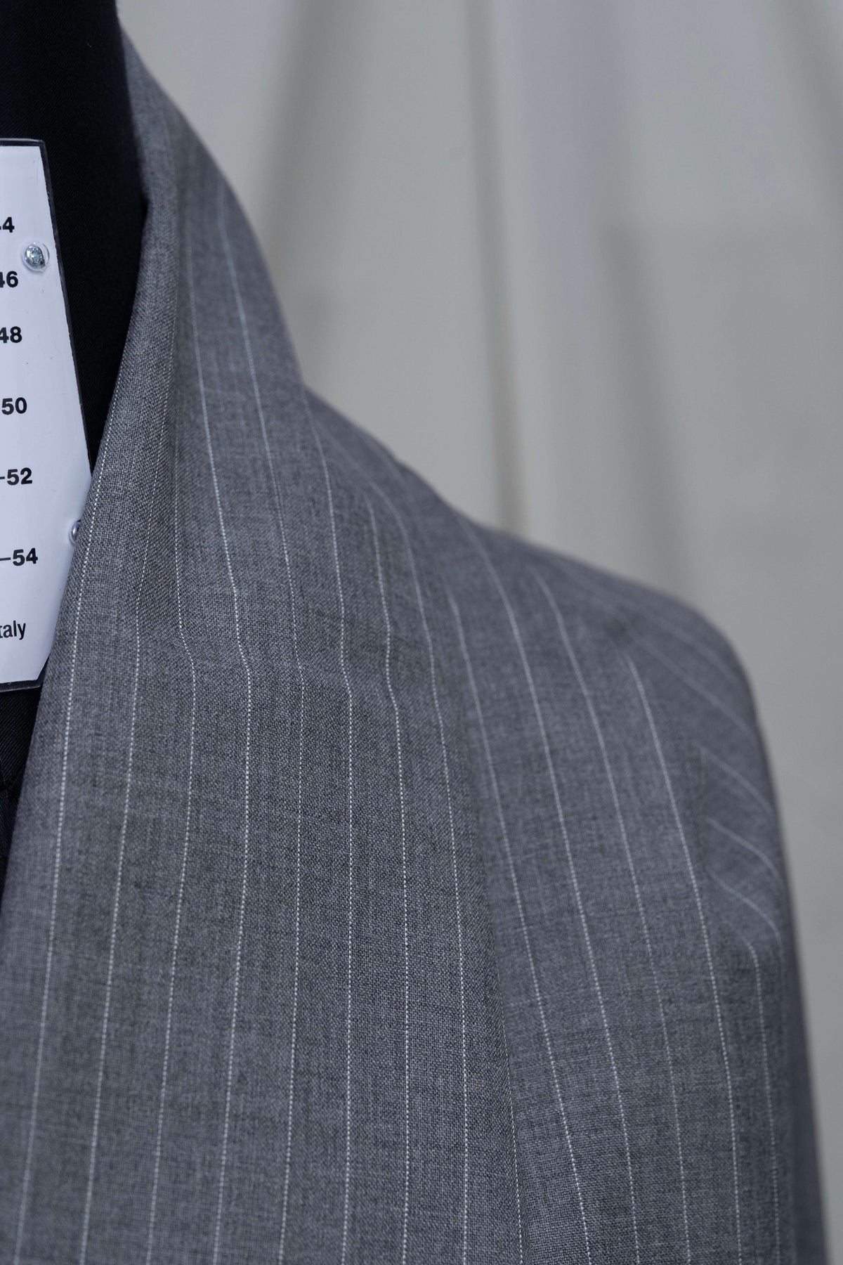 Close-up of grey stripe wool suiting fabric showcasing fine stripes and texture on the collar design.