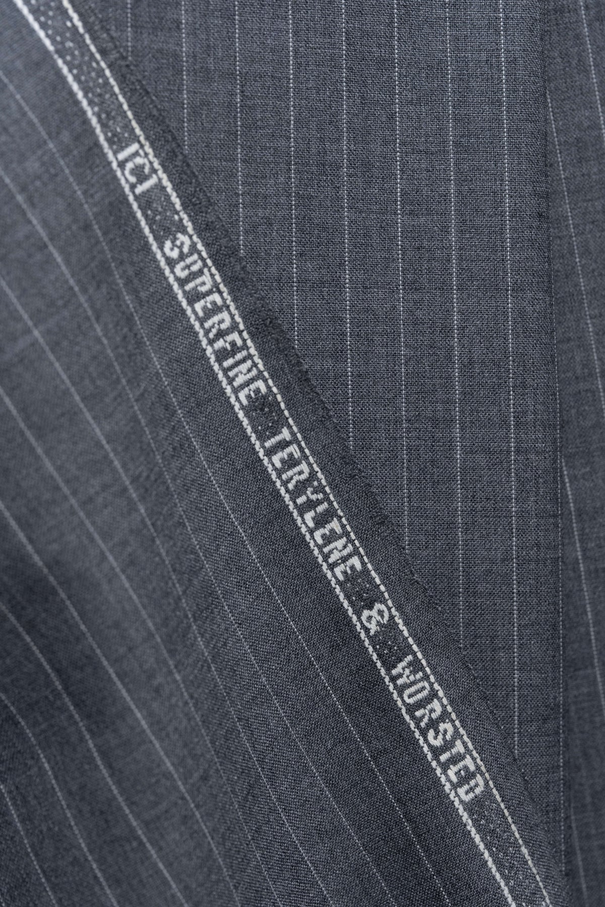 Grey stripe wool suiting fabric showcasing fine texture and durability, perfect for stylish tailored trousers.