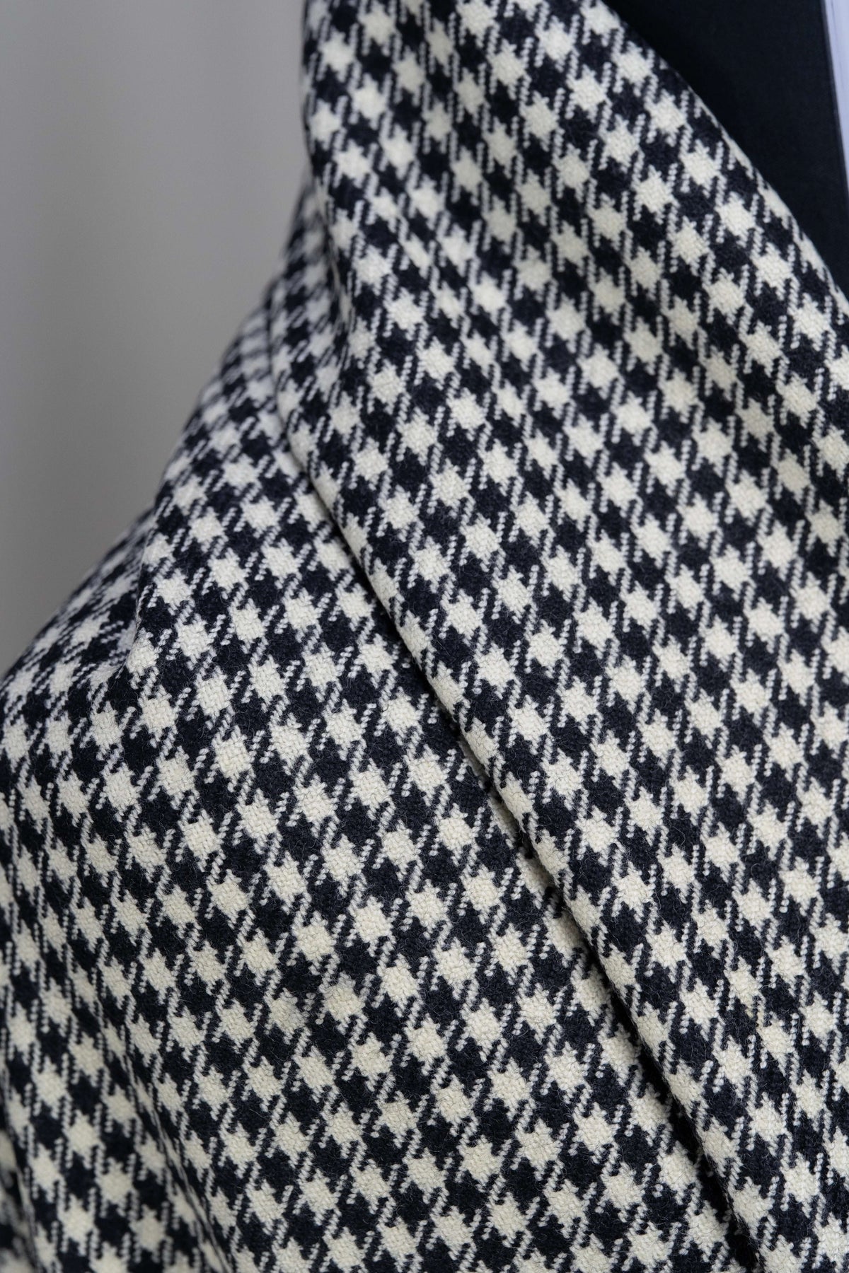 Houndstooth wool jacketing fabric display showcasing the classic black and white pattern detail.