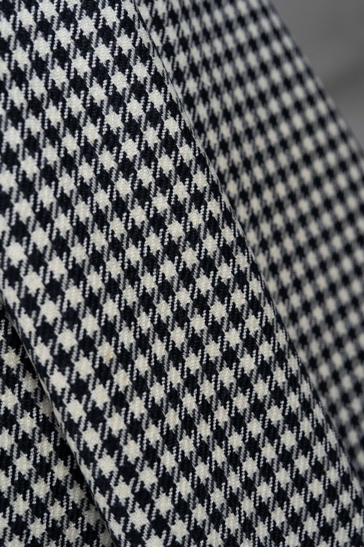 Close-up of houndstooth wool jacketing fabric showcasing its unique pattern and texture.