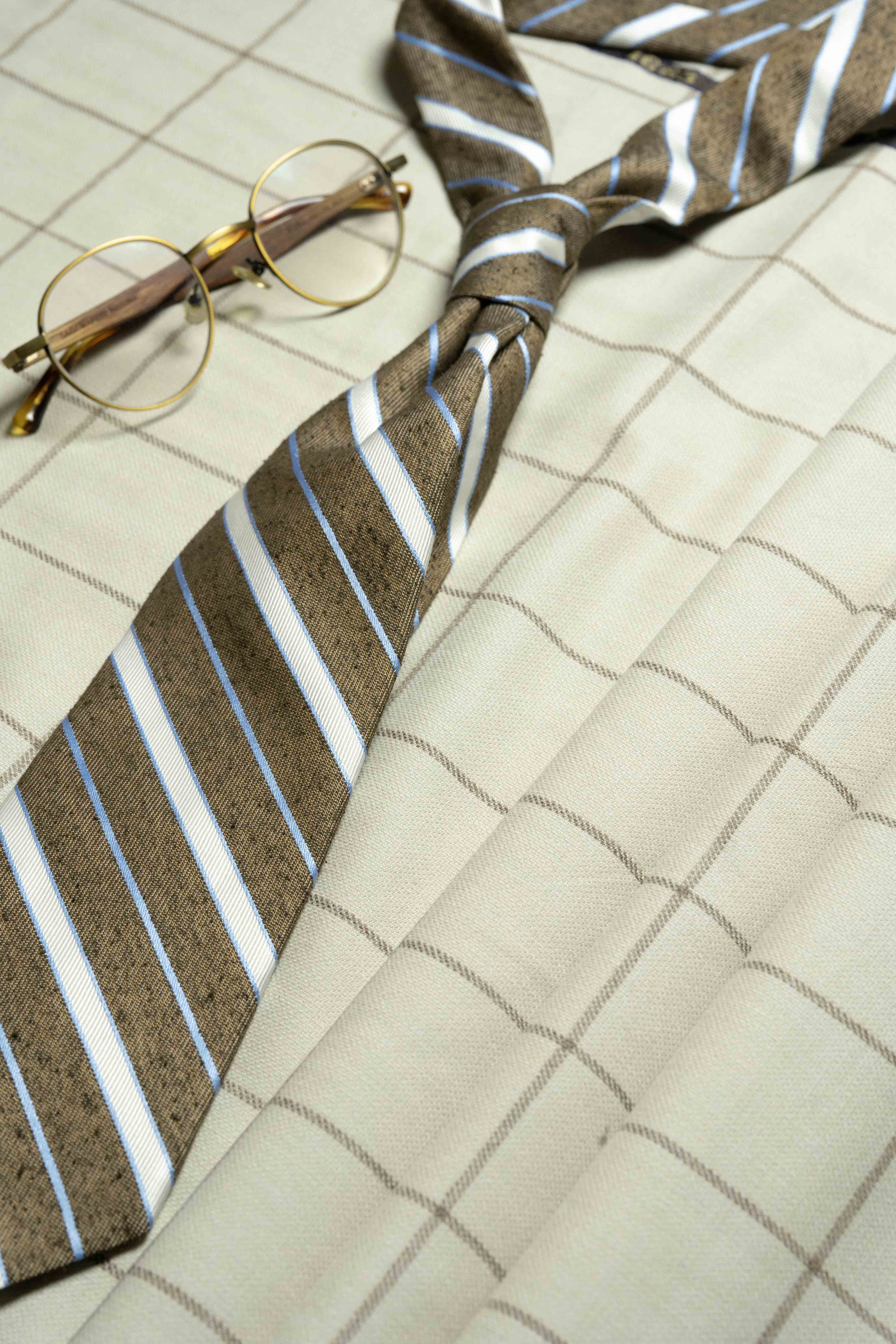 VBC Beige Check Wool & Cashmere Jacketing fabric with a striped tie and round glasses.