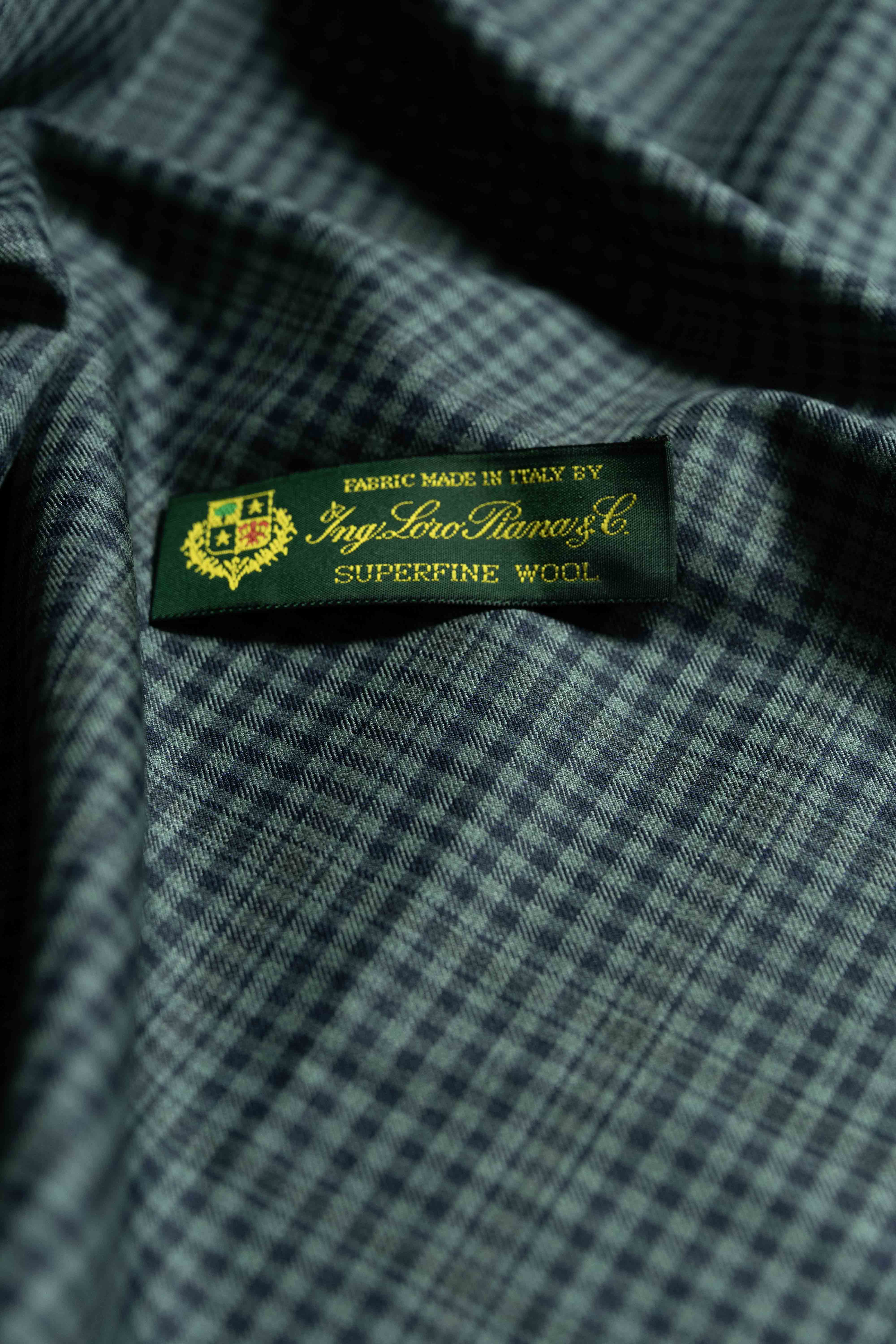 Loro Piana dark teal wool fabric featuring a label for Superfine Wool, made in Italy.