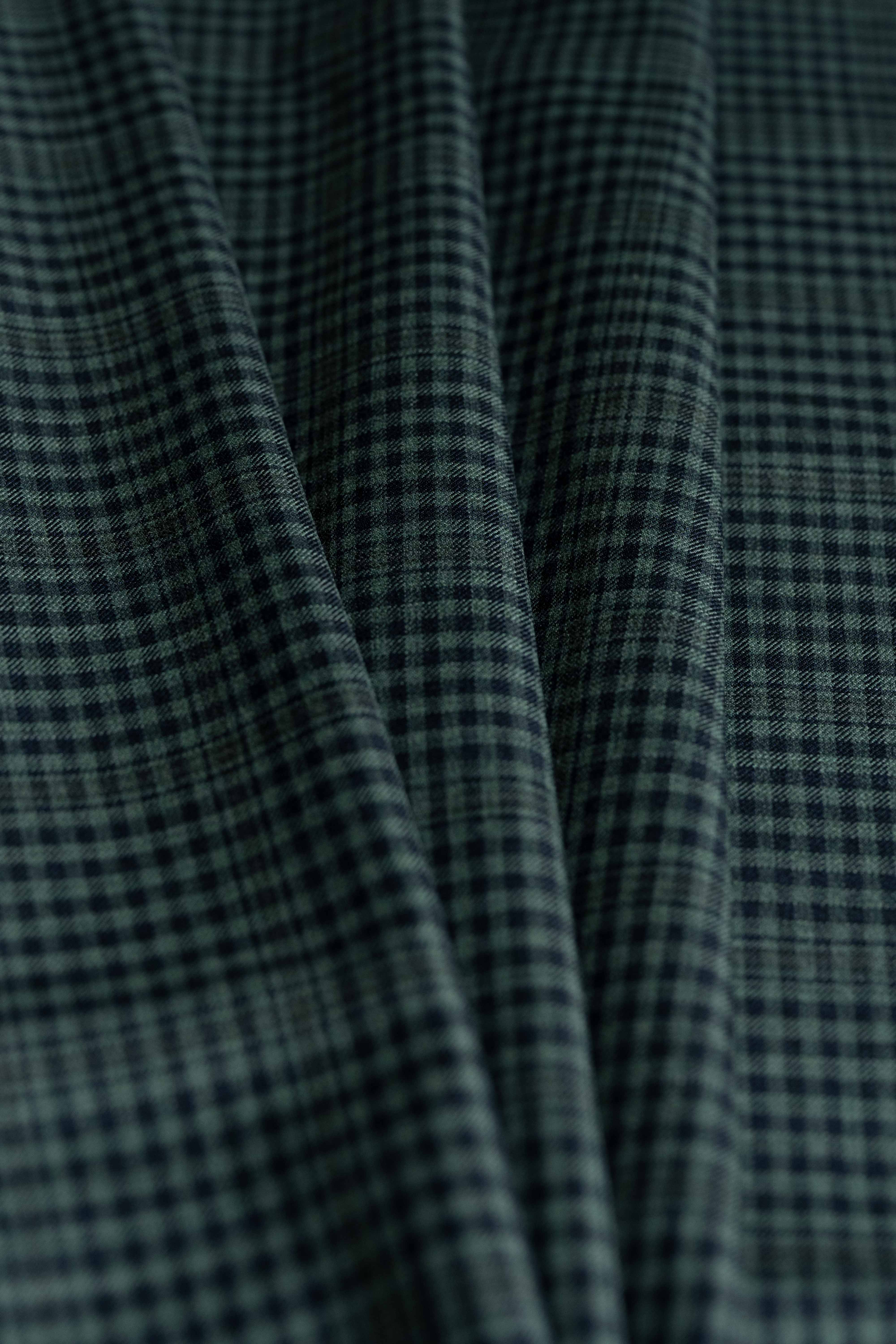 Loro Piana dark teal wool fabric featuring a fine check pattern, ideal for luxury tailoring.