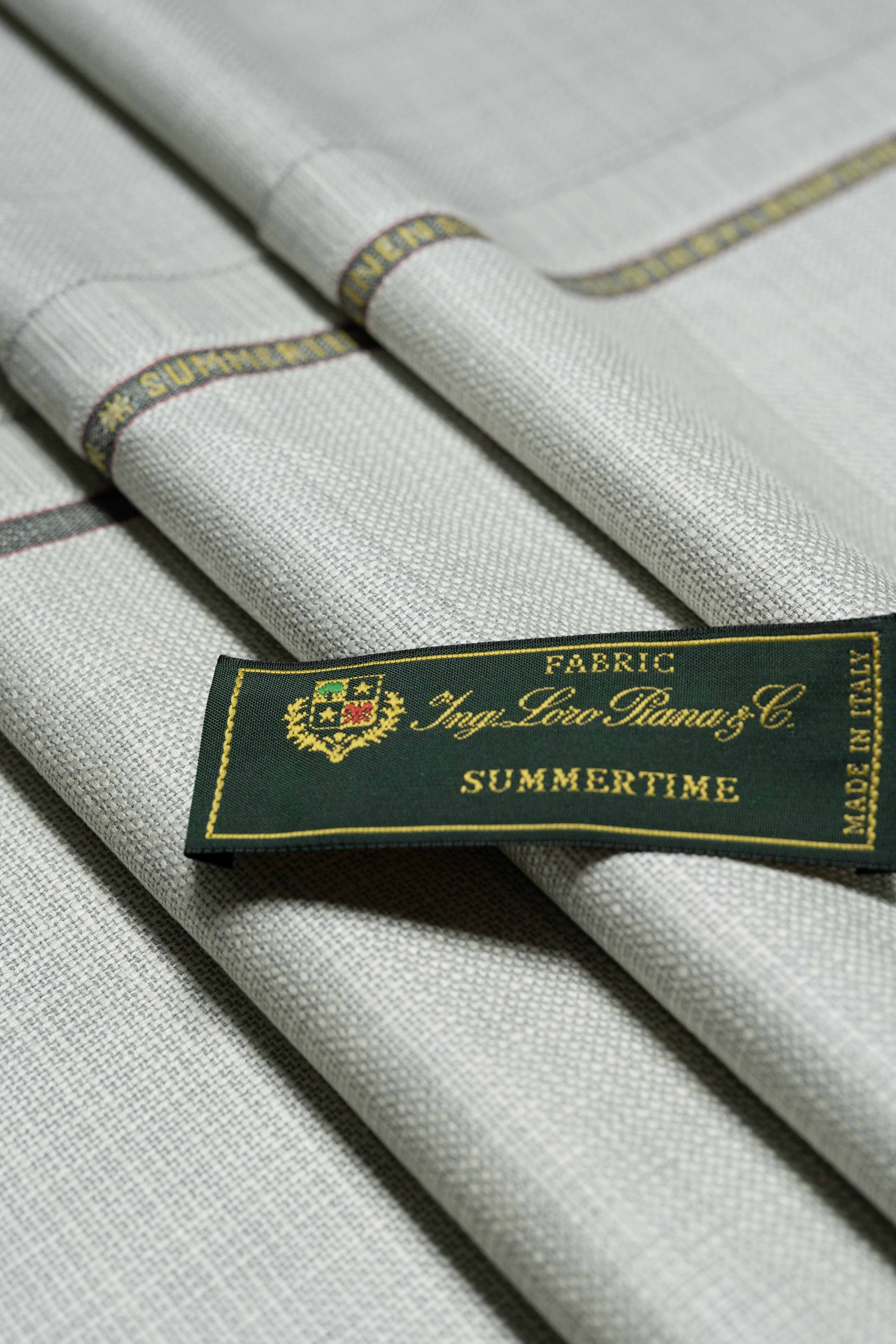 Loro Piana Beige Wool Silk Linen Jacket Fabric with Summertime label folded on soft fabric.