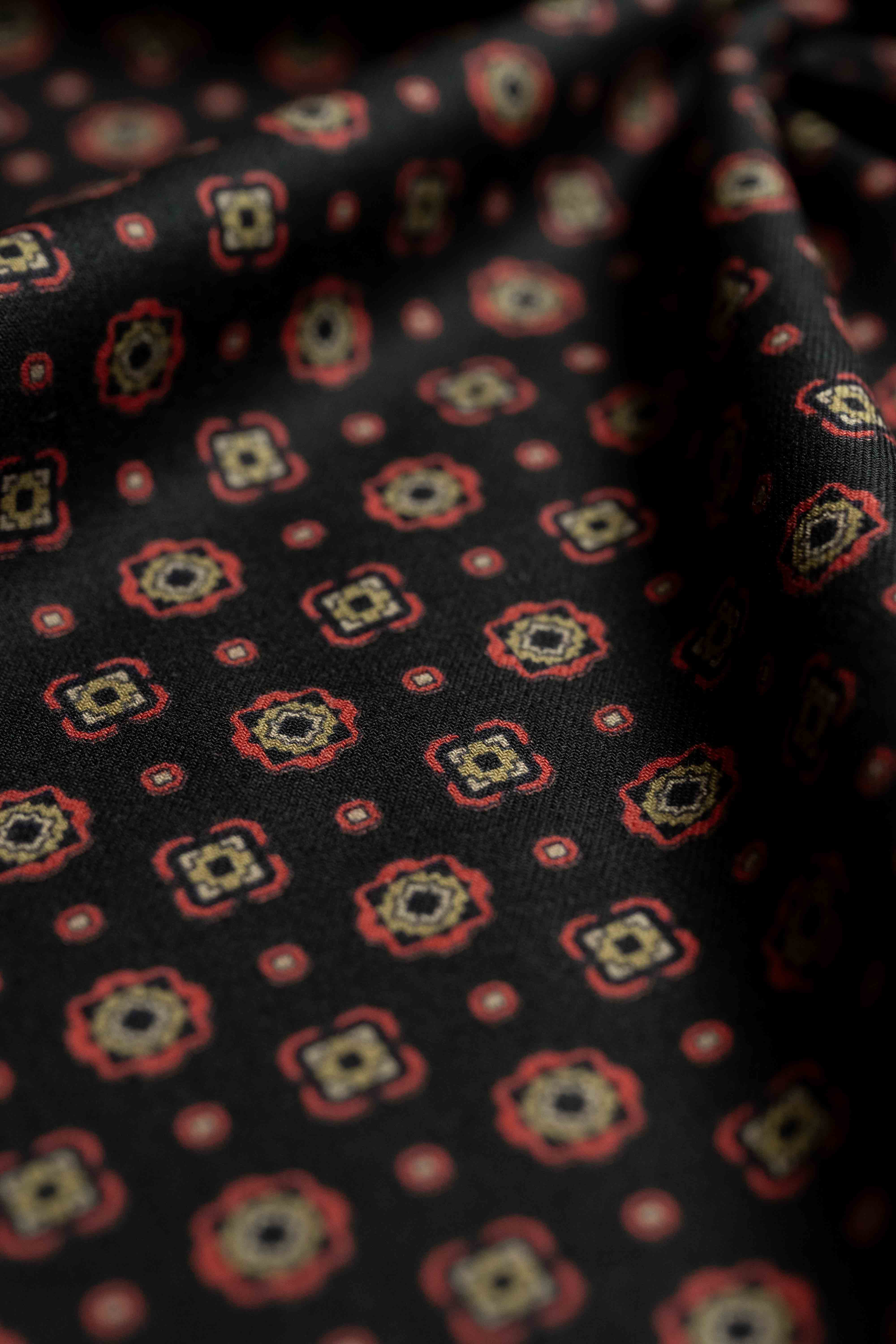 Vintage fabrics in rich black background with colorful geometric patterns perfect for shirts or ties.