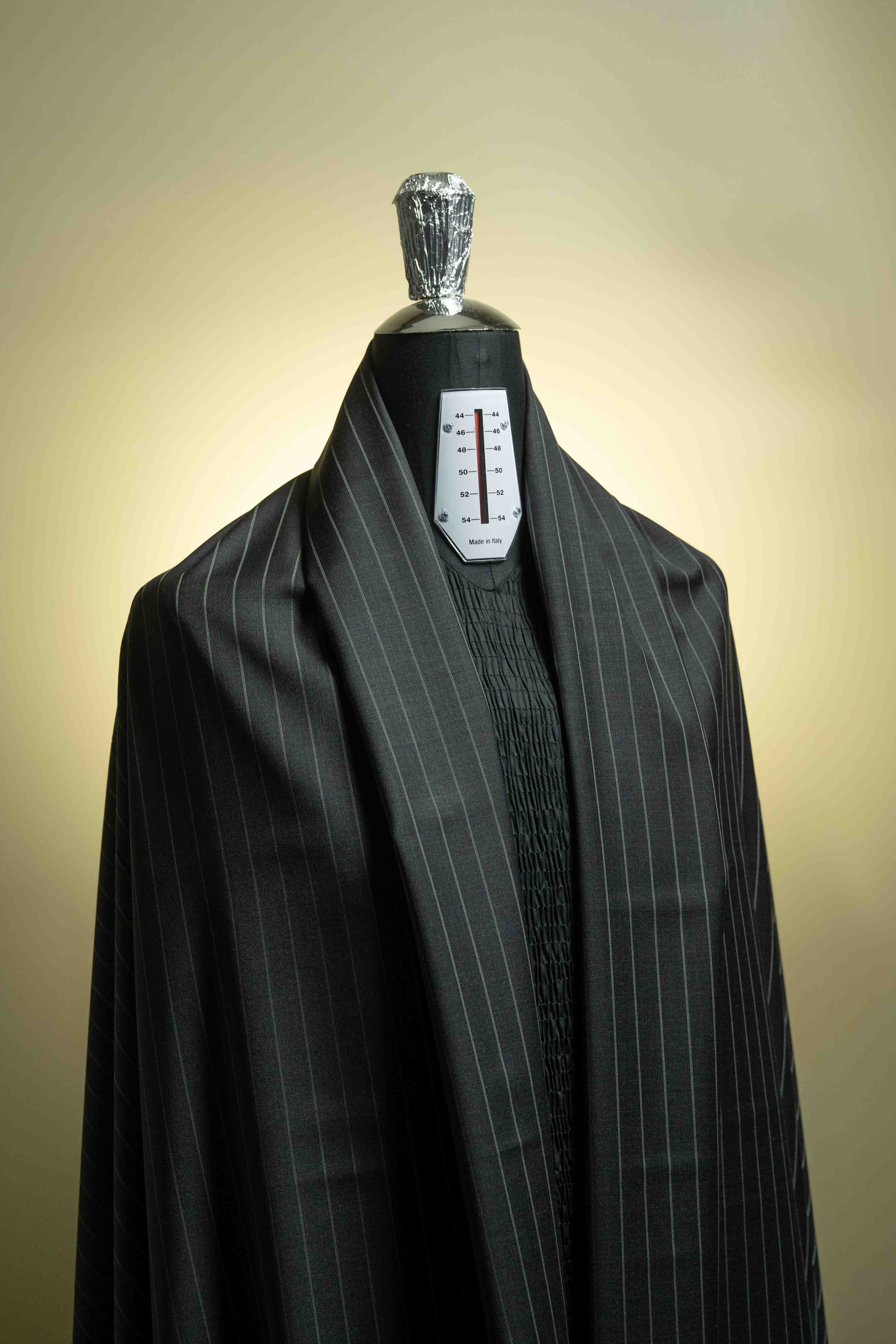 Charcoal stripe 150's & Cashmere suiting displayed on a dress form showcasing its luxurious texture.
