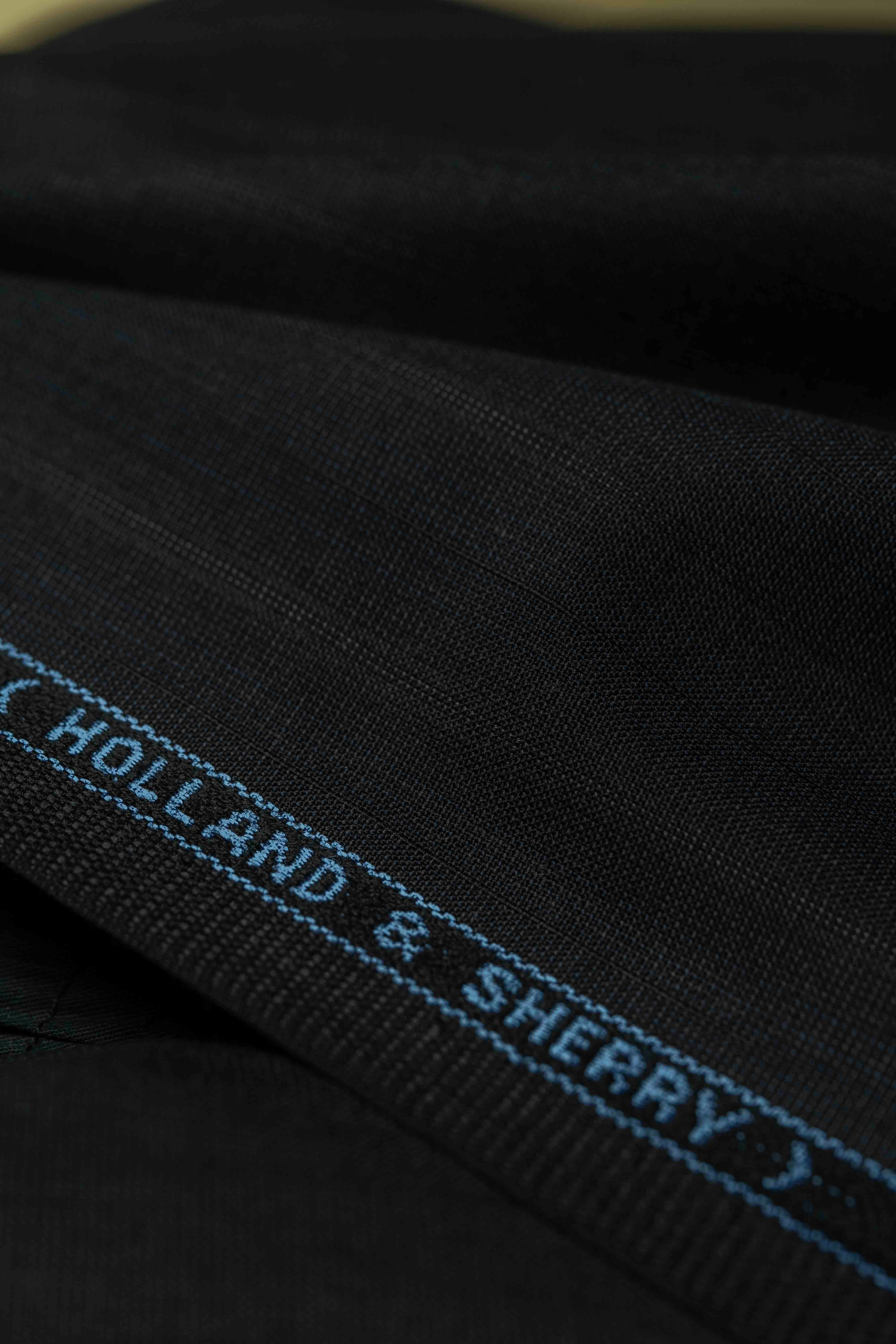 Holland & Sherry Fabric close-up showcasing charcoal stripe detail on high-quality suiting material.