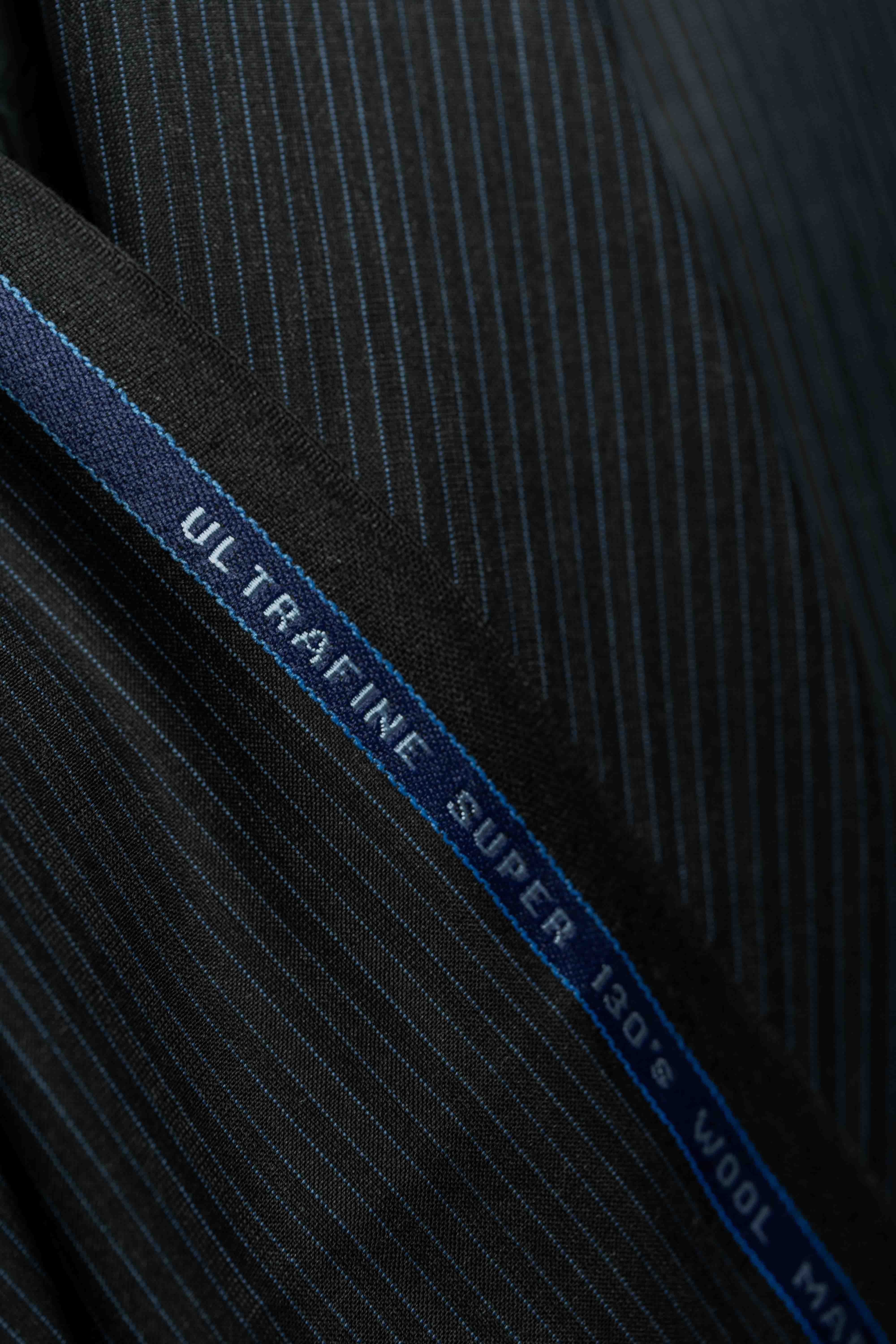 Lassiere Charcoal Blue Stripe 130's Suit fabric displaying ultrafine texture and vibrant stripes, perfect for tailored designs.