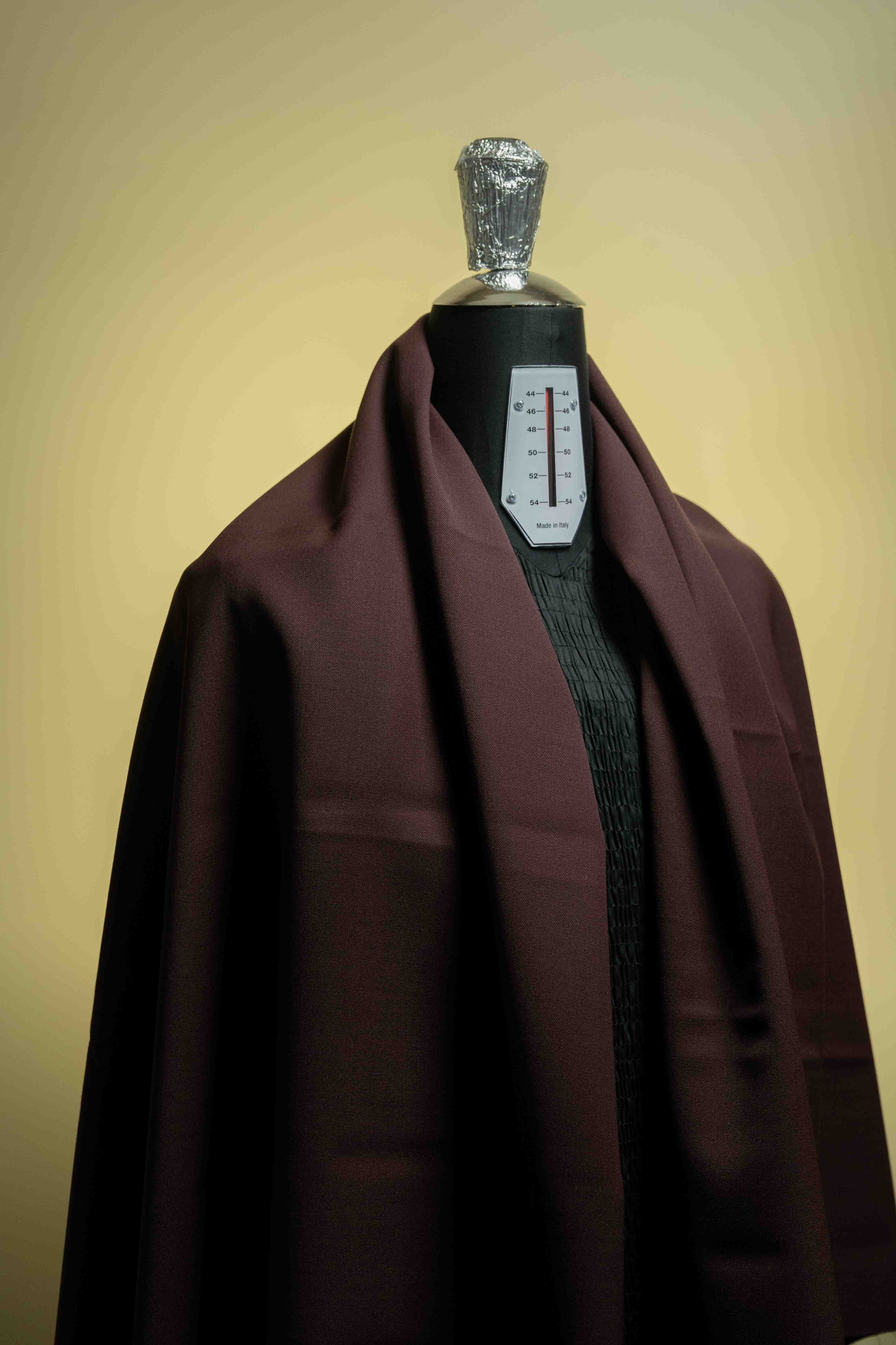 Red minkcash draped on a mannequin to showcase the luxurious suit fabric quality.