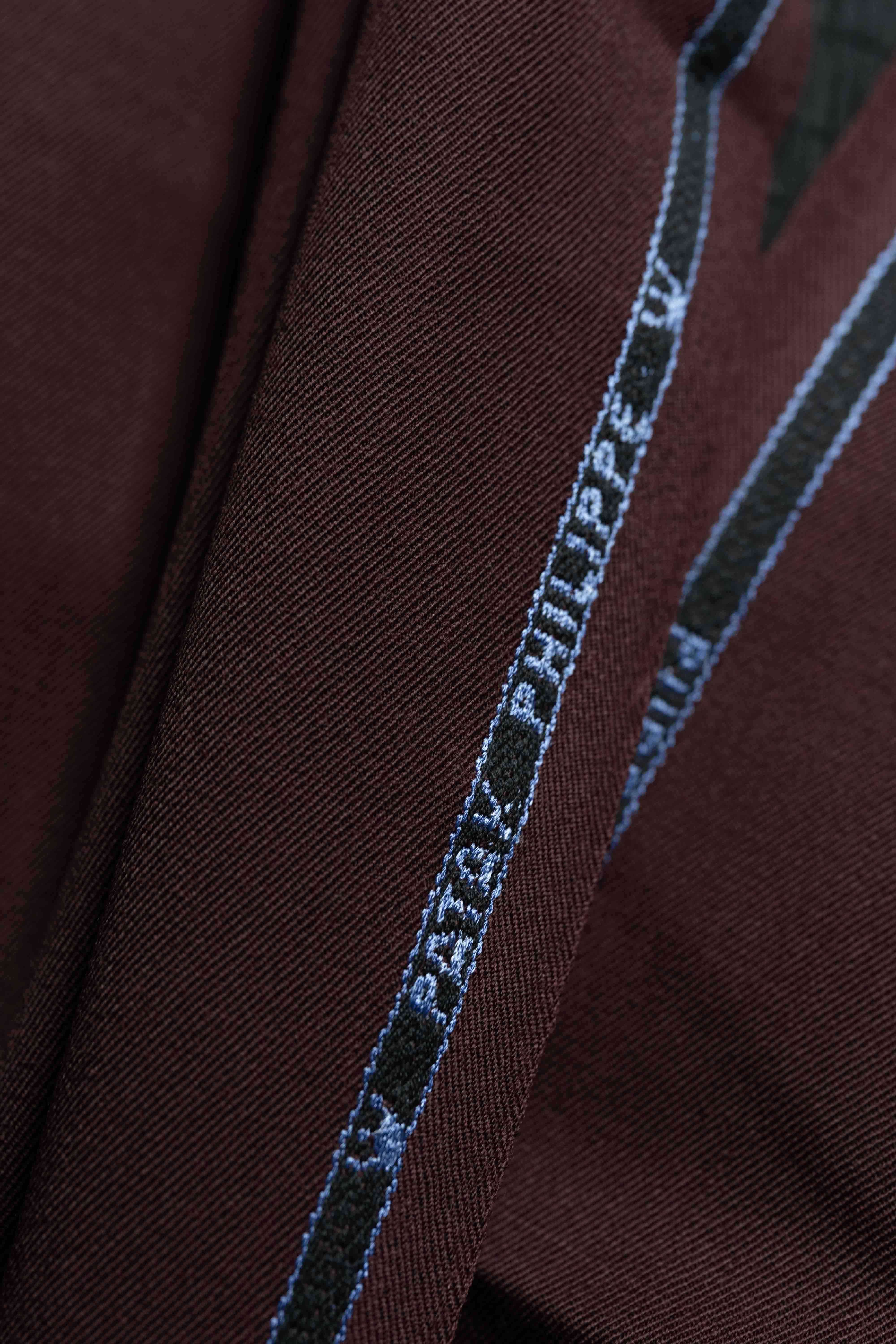Close-up of red minkcash suit fabric with detailed stitching, perfect for stylish trousers.