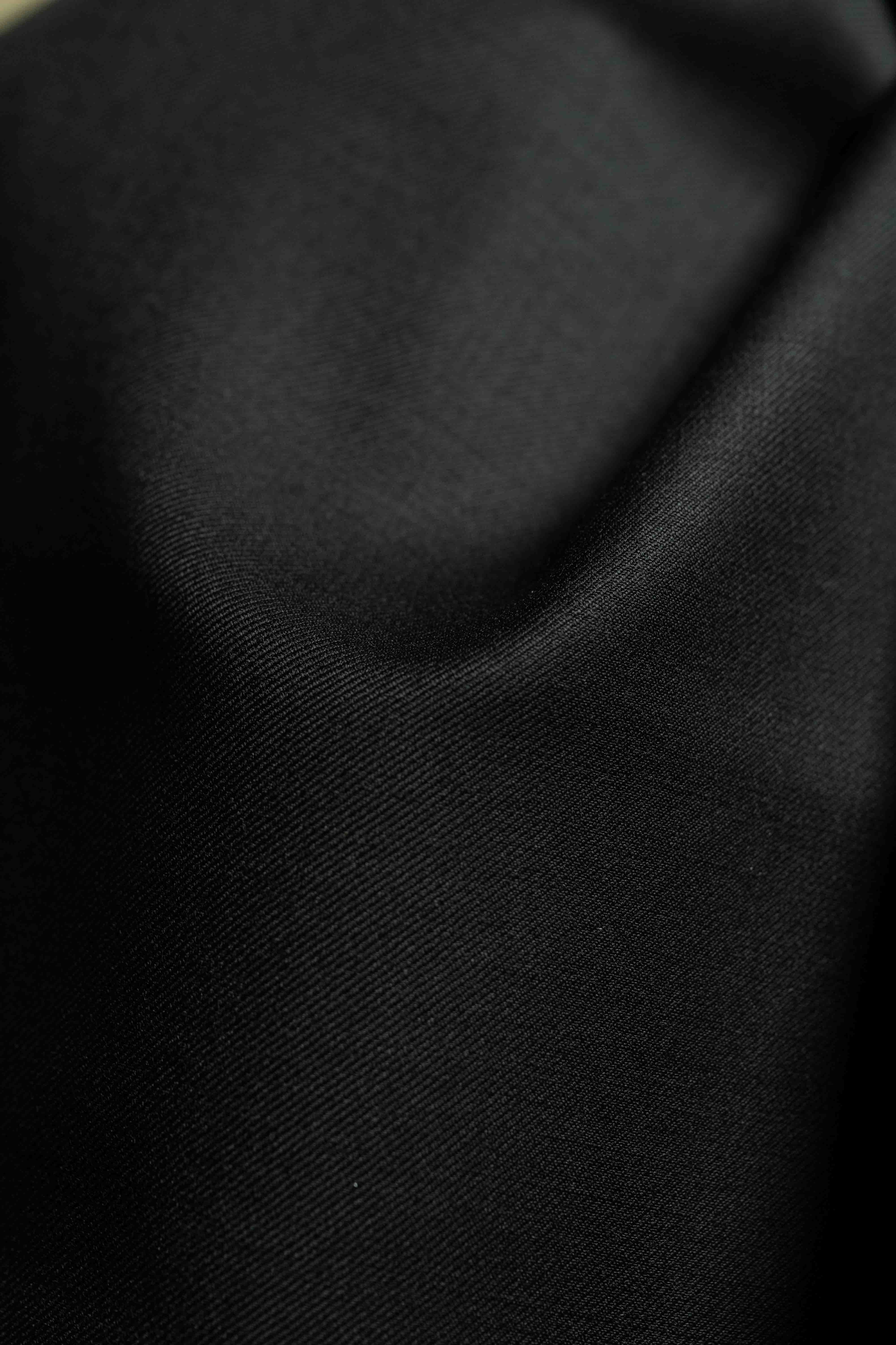 Black fabric close-up of a Black Merino Cashmere Wool with Silk Suit Jacket featuring luxurious Cashmere material.