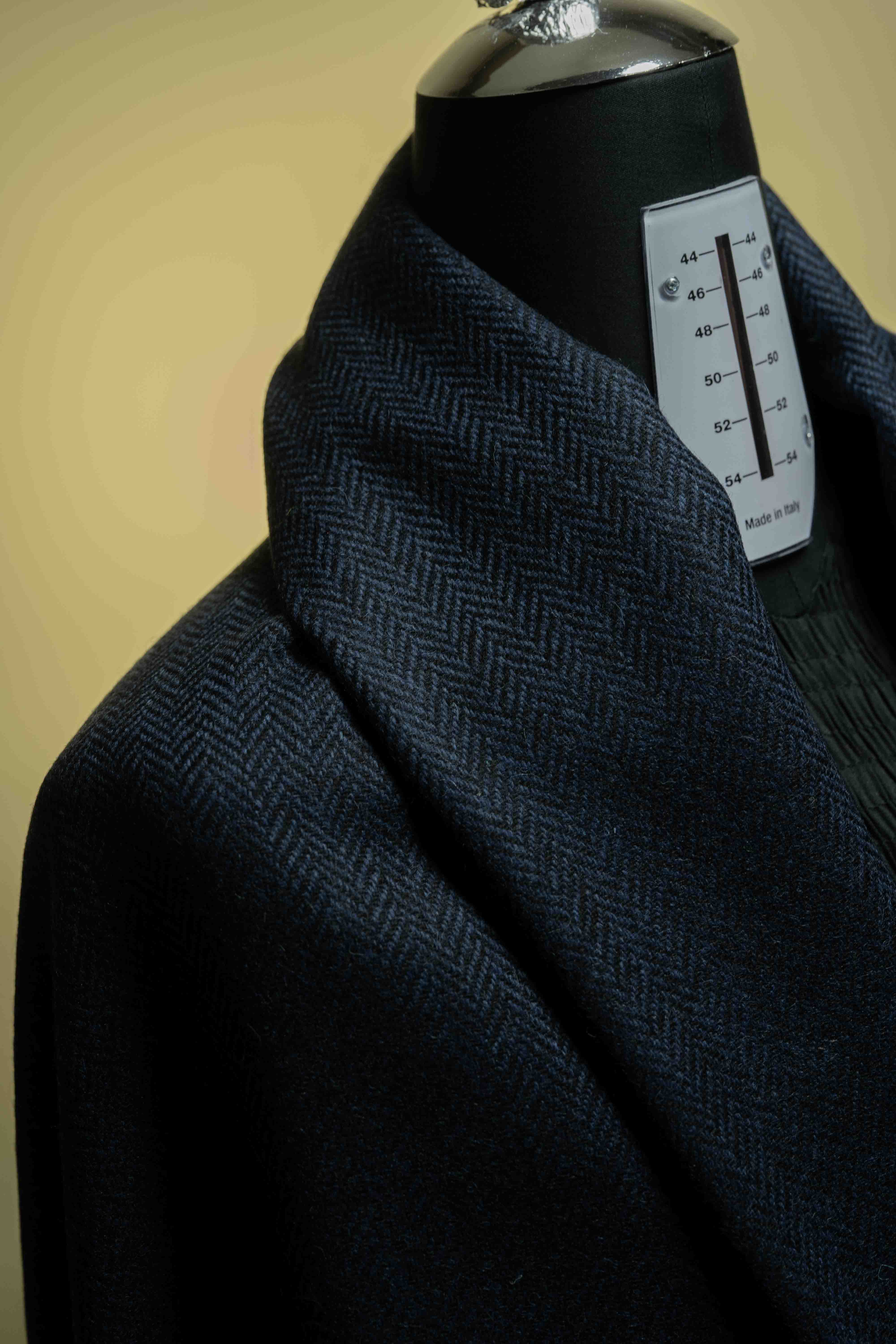 Navy herringbone wool suit jacket showcasing premium suit fabric on a mannequin.