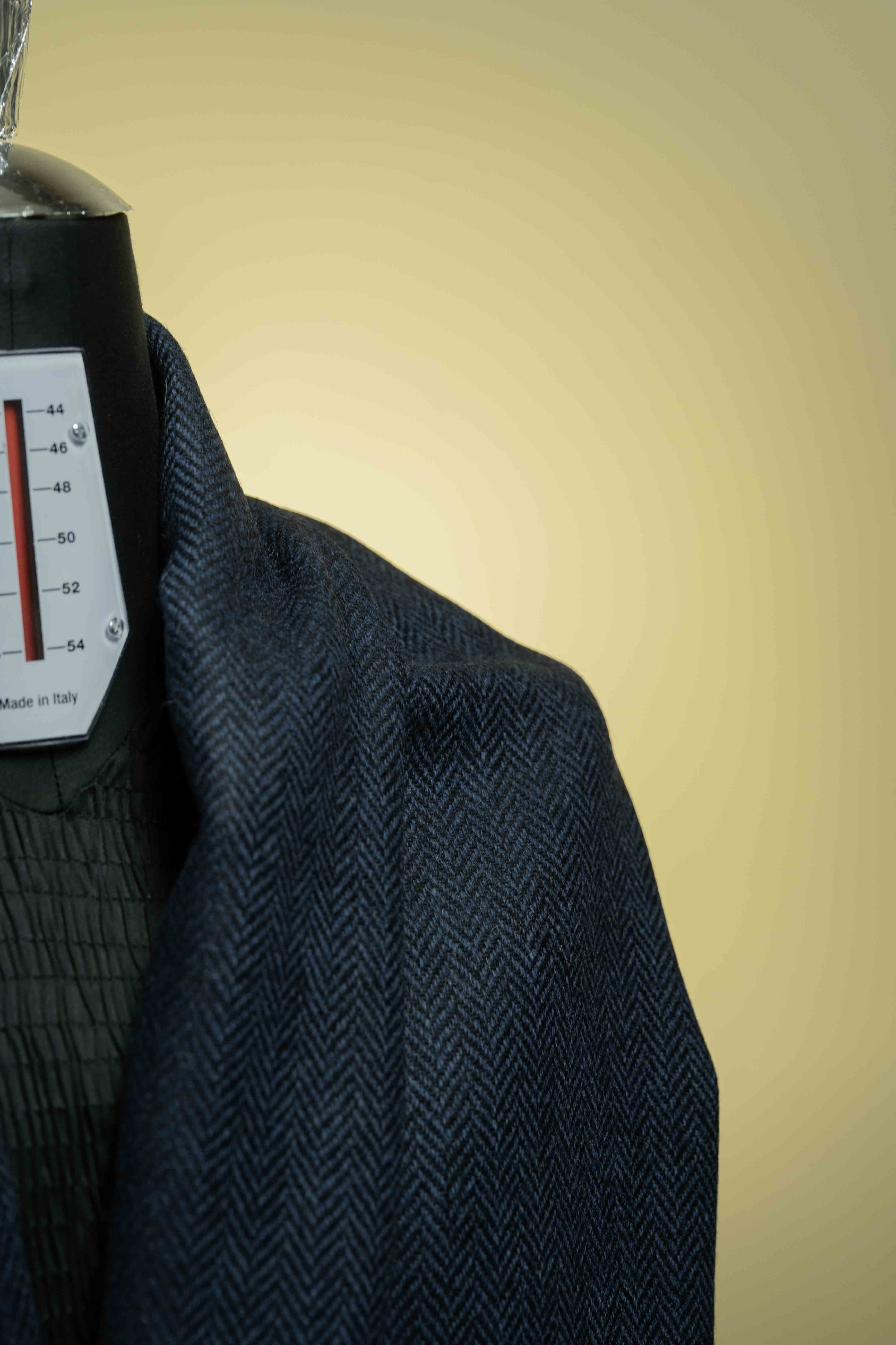 Navy herringbone wool suit jacket fabric displayed on a mannequin, showcasing high-quality suit fabric texture.
