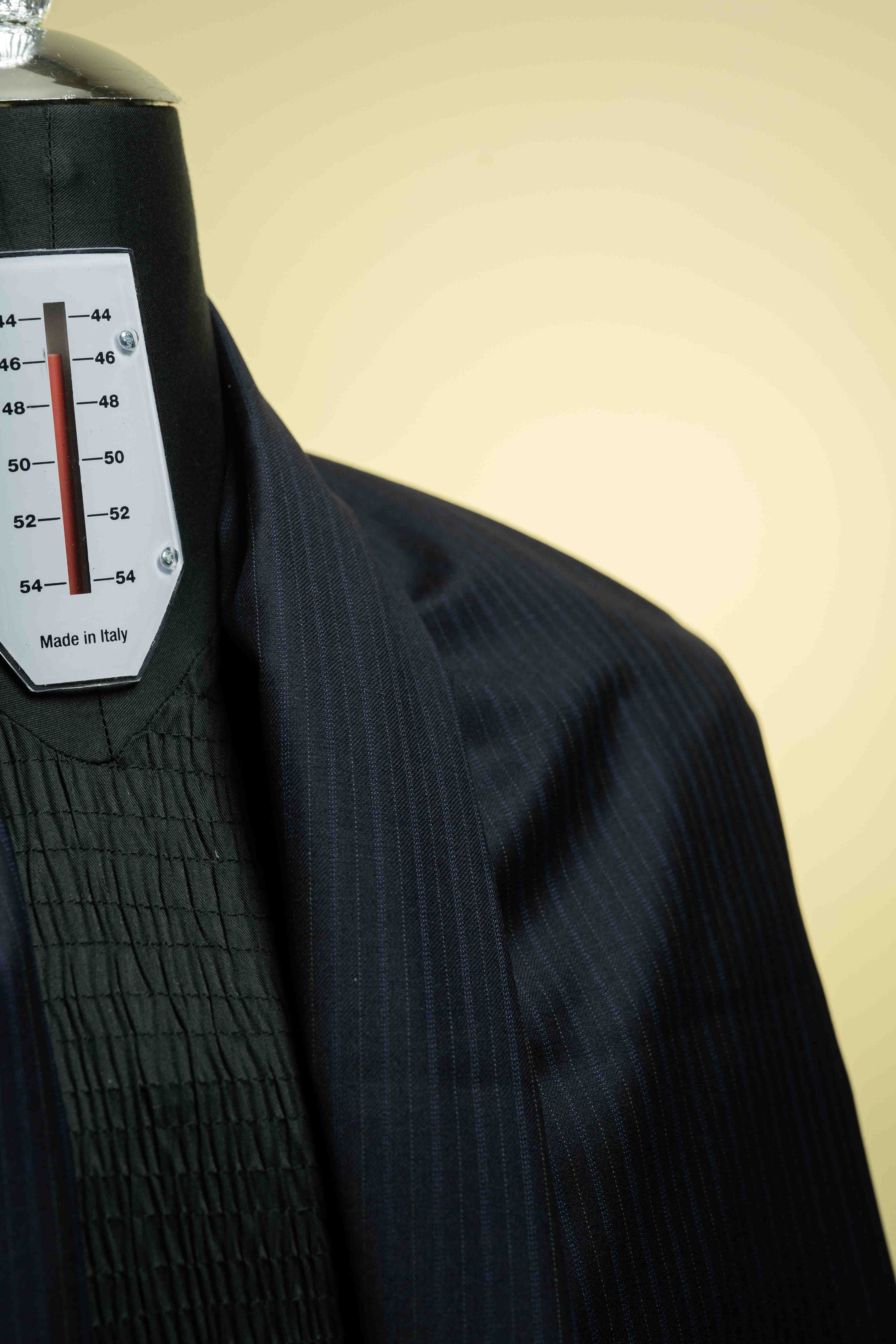Black pinstripe suit jacket on a mannequin with a temperature gauge label.