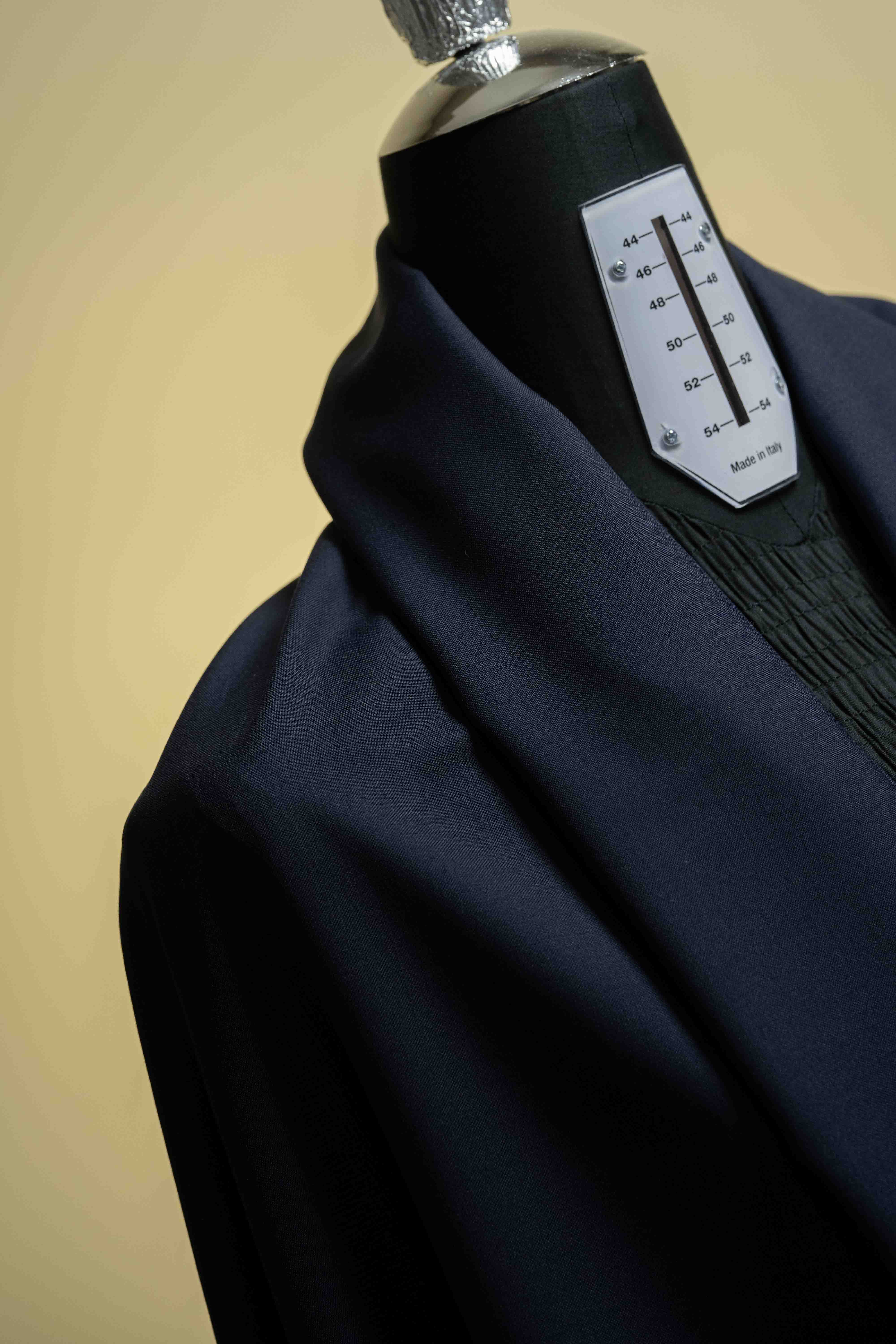 Navy Suiting fabric draped on a dress form, showcasing the luxurious texture of Super 100's Wool & Cashmere.