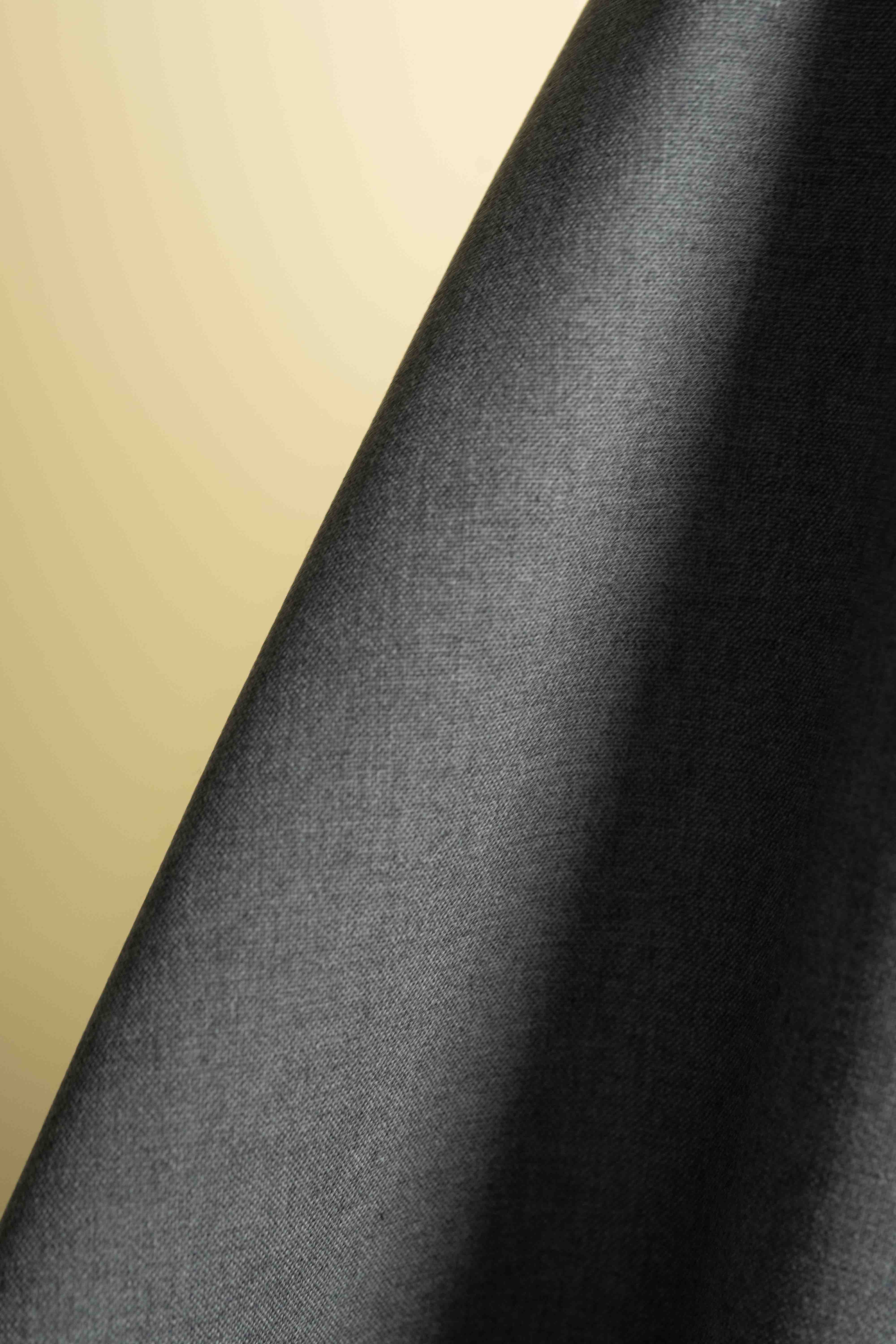 Close-up of dark gray fabric with a beige background