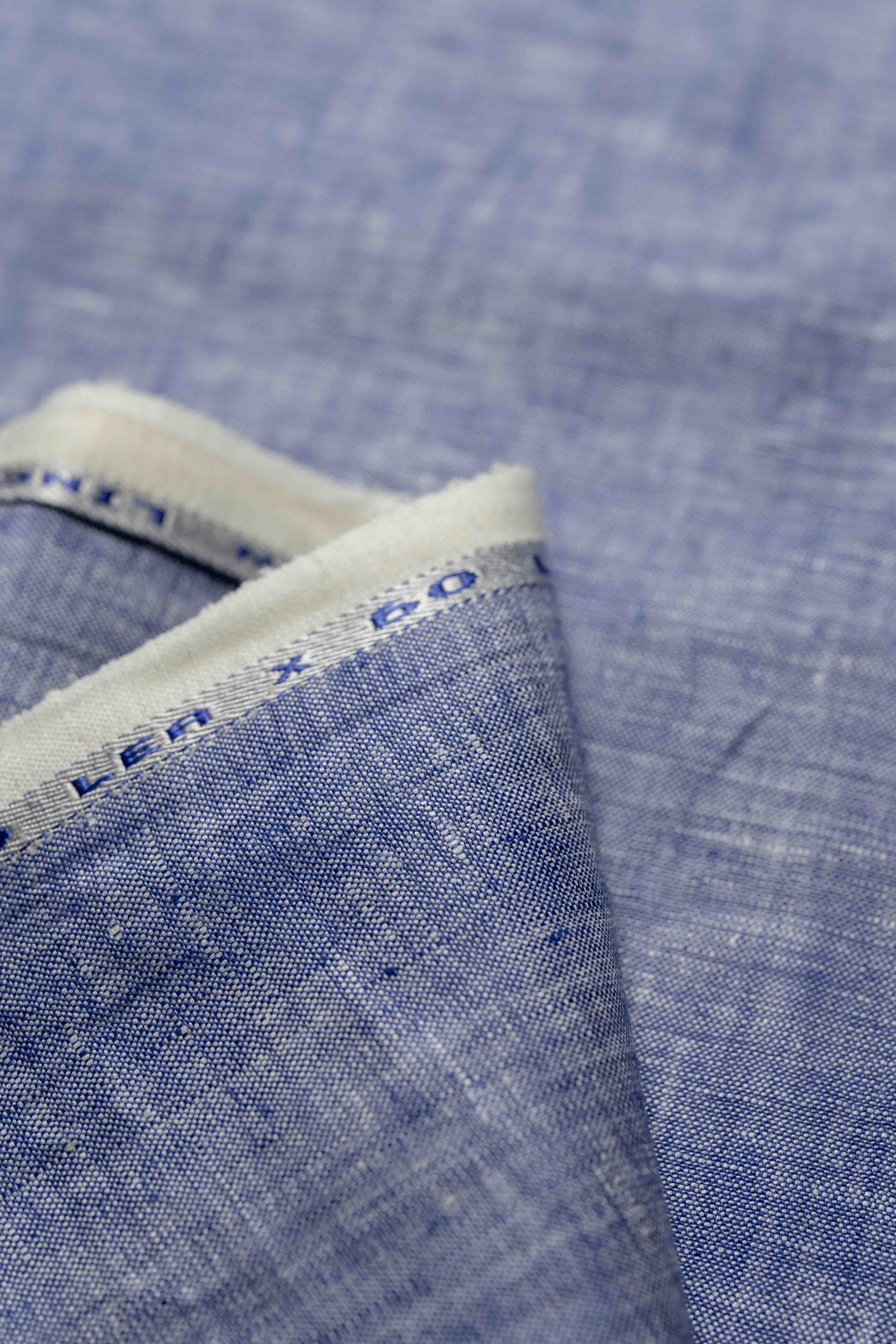 Close-up of blue fabric with a pattern, showing texture and color details.